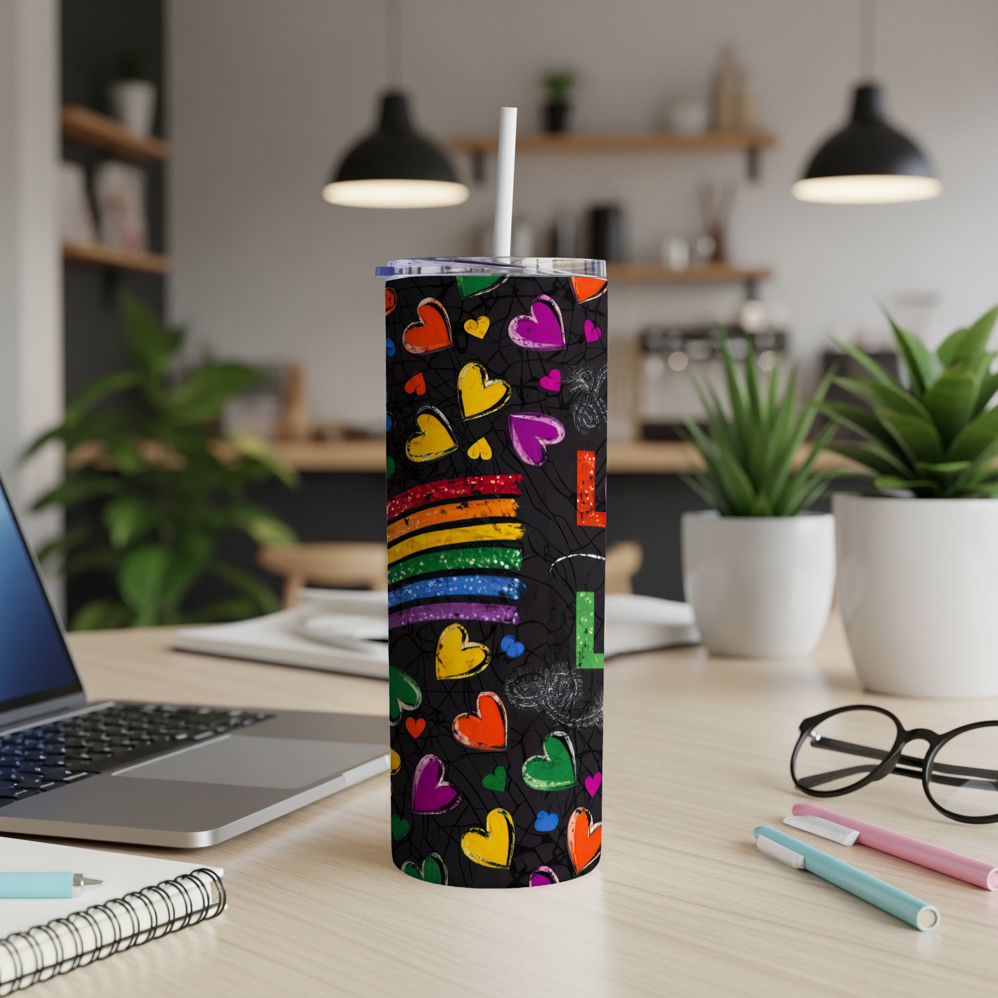 Rainbow hearts and stripes pattern on a black tumbler with a straw.