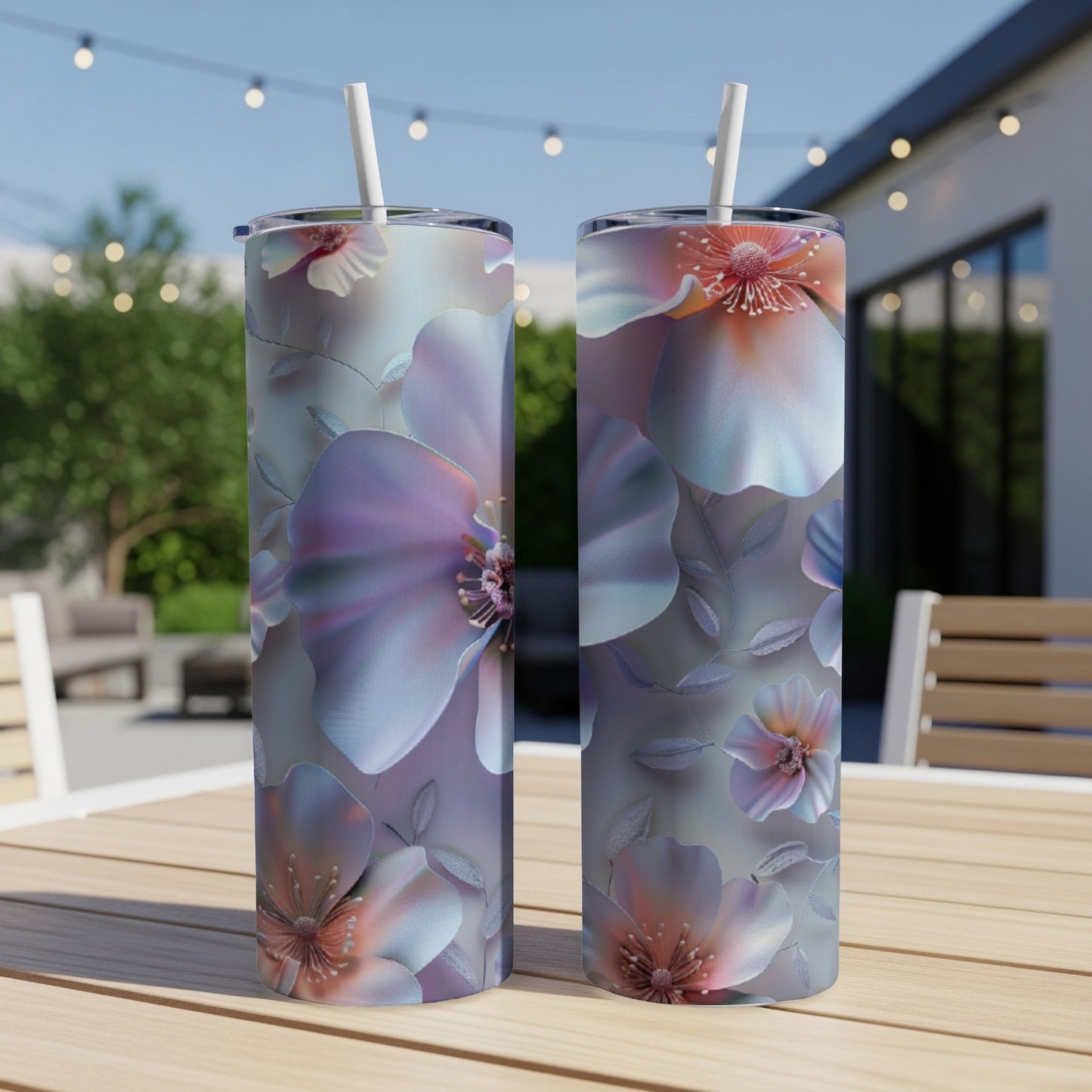 Two tall tumblers with floral designs sit on a table.