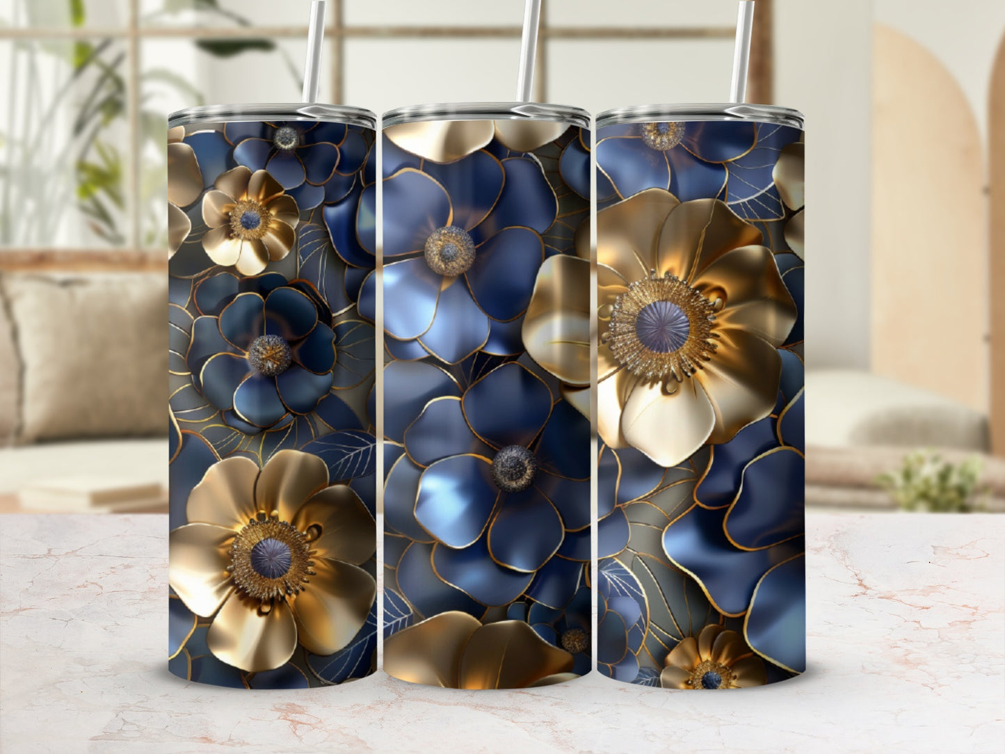 Three blue and gold floral tumblers with straws on a marble surface.