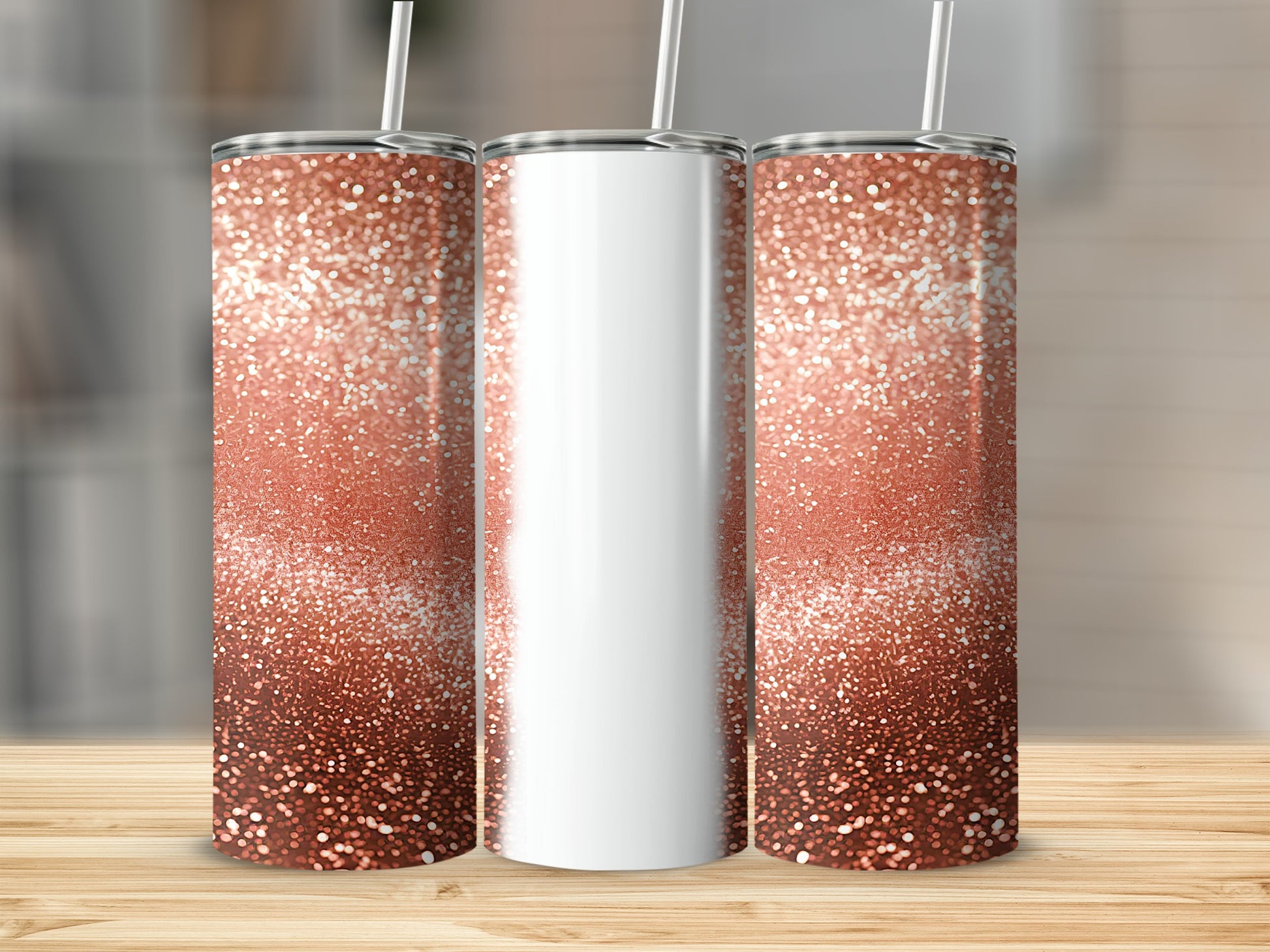 Three rose gold glitter tumblers with white straws on a wooden surface.