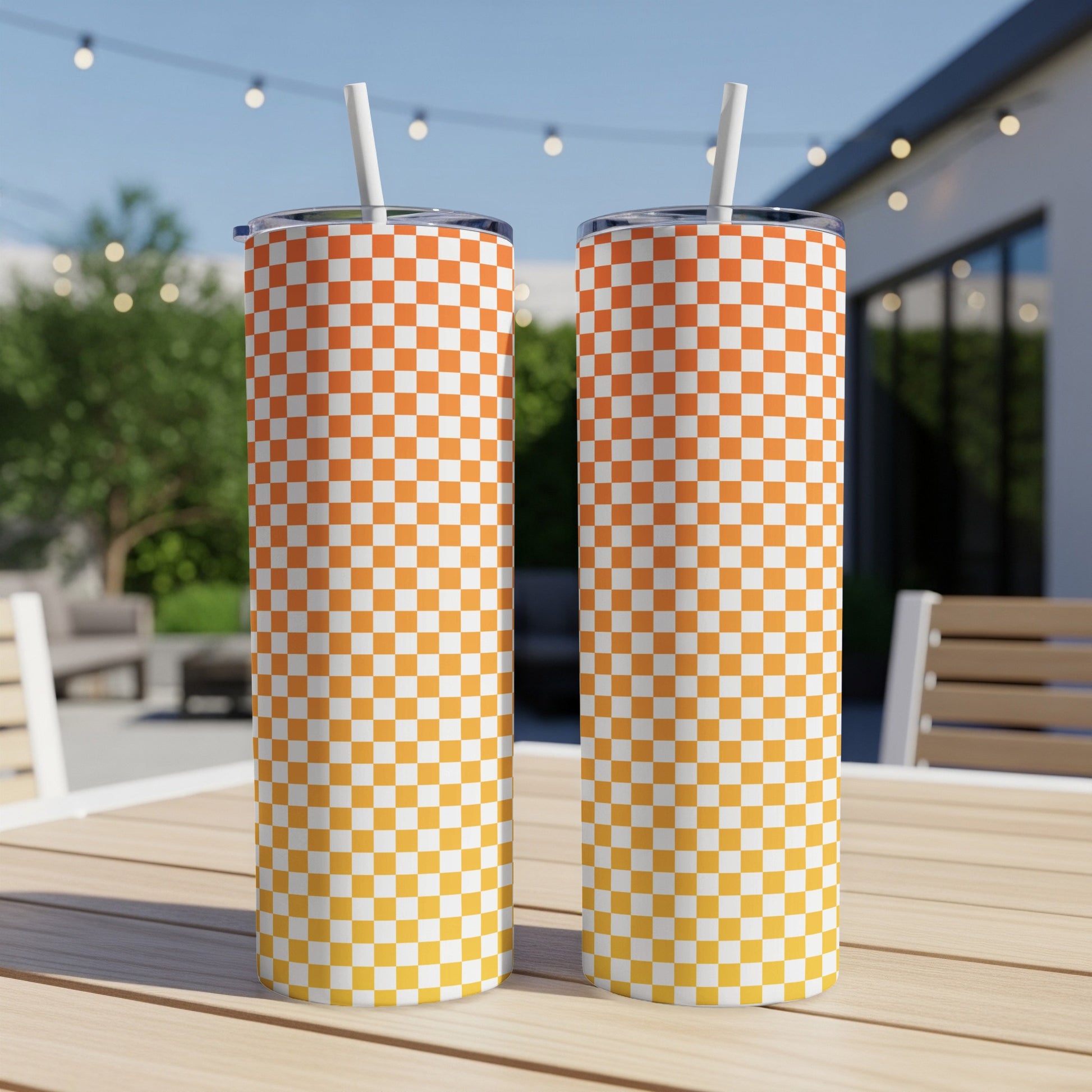 Two checkered tumblers with orange and yellow gradients on a wooden table.