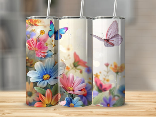 Three tumblers featuring colorful flowers and butterflies on a wooden surface.