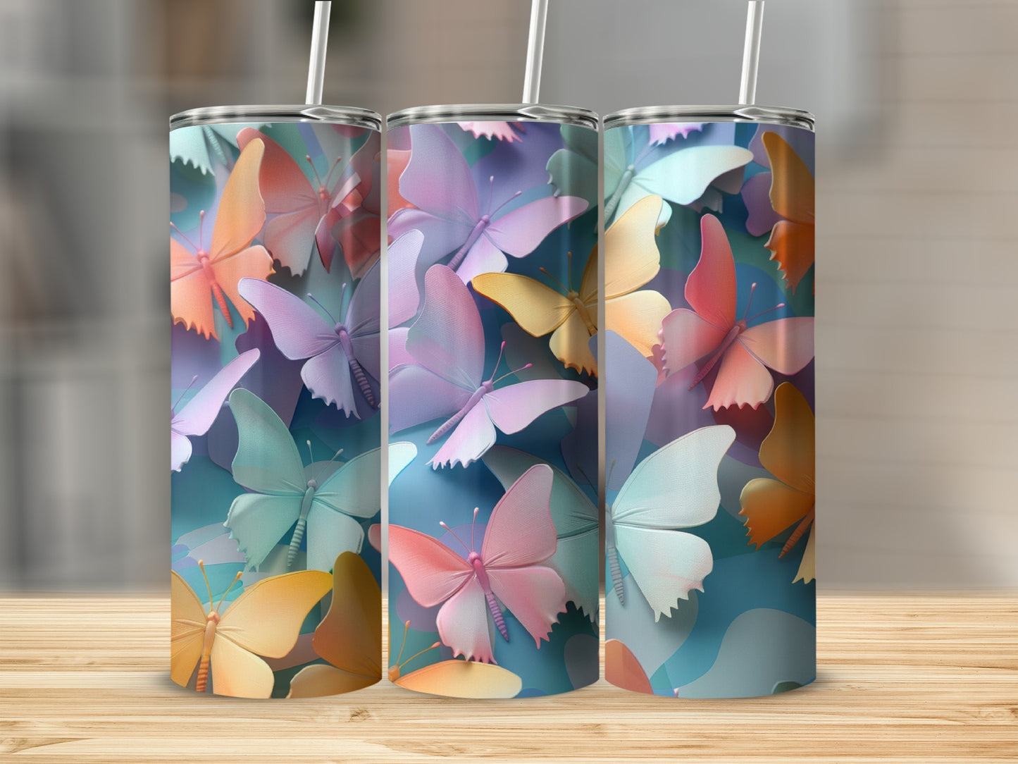 Three tumblers with colorful butterfly patterns arranged on a wooden surface.