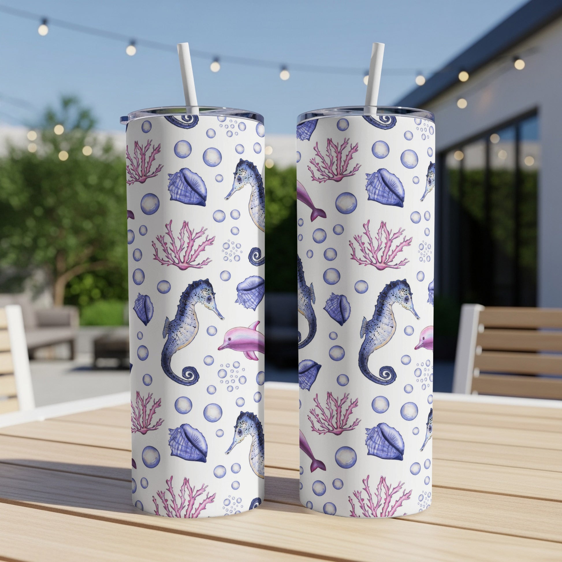 Two tumblers with seahorses, dolphins, shells, and coral on white speckled background.