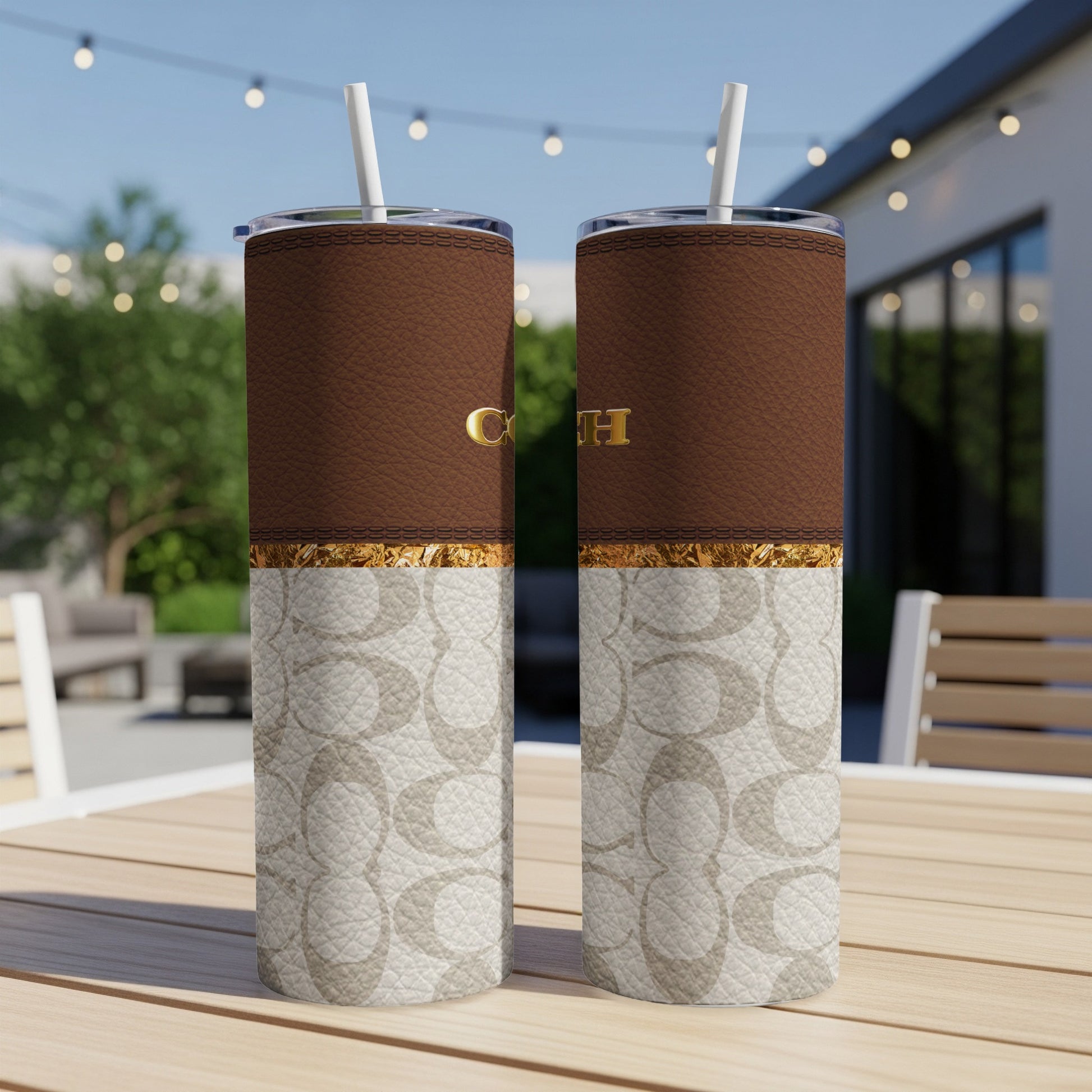 Coach print tumblers with brown textured top and gold buckle accent.