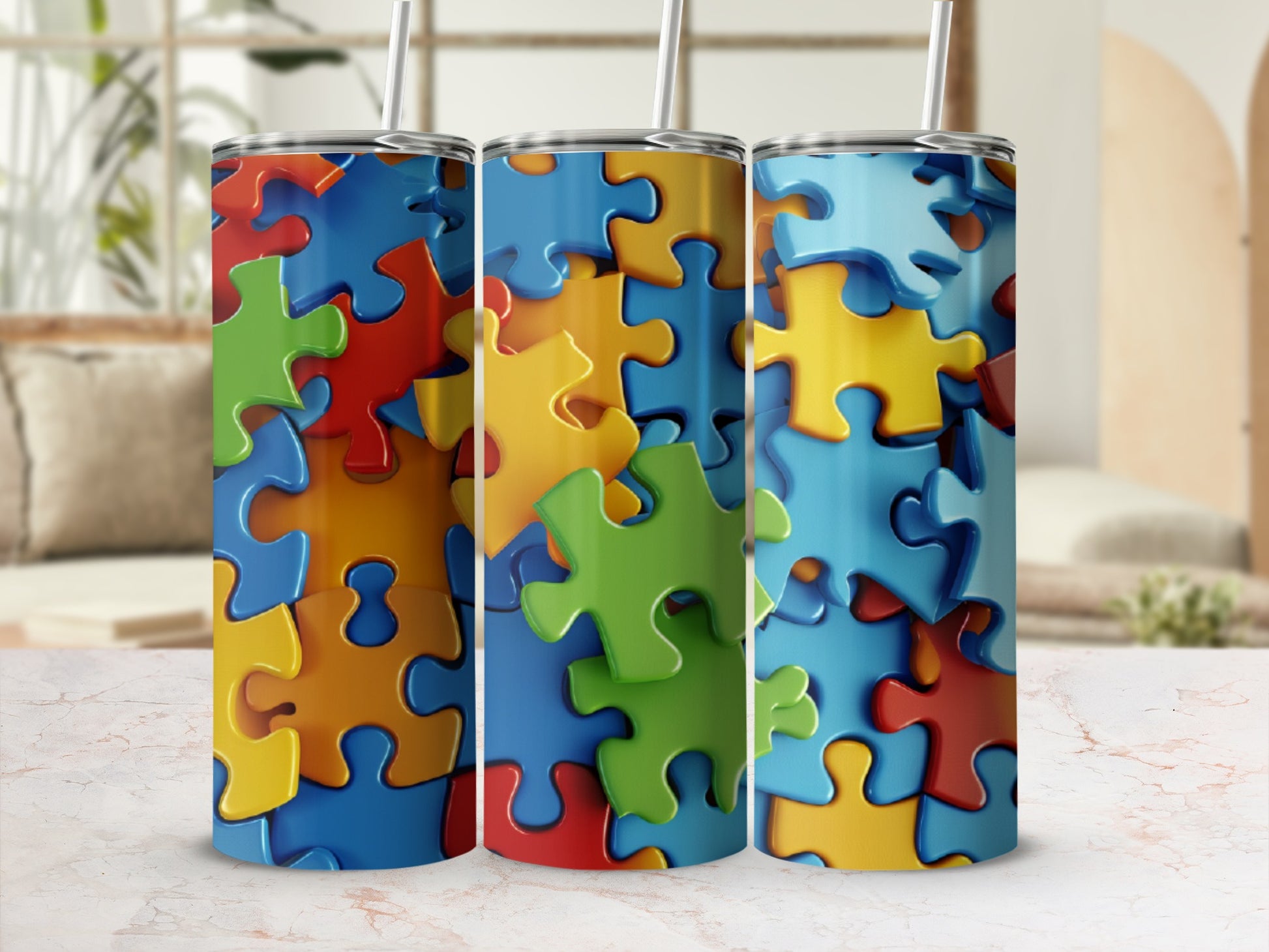 Three colorful puzzle piece patterned tumblers with straws.
