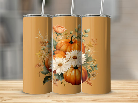 Three orange tumblers with pumpkins, roses, and daisies on a wooden surface.