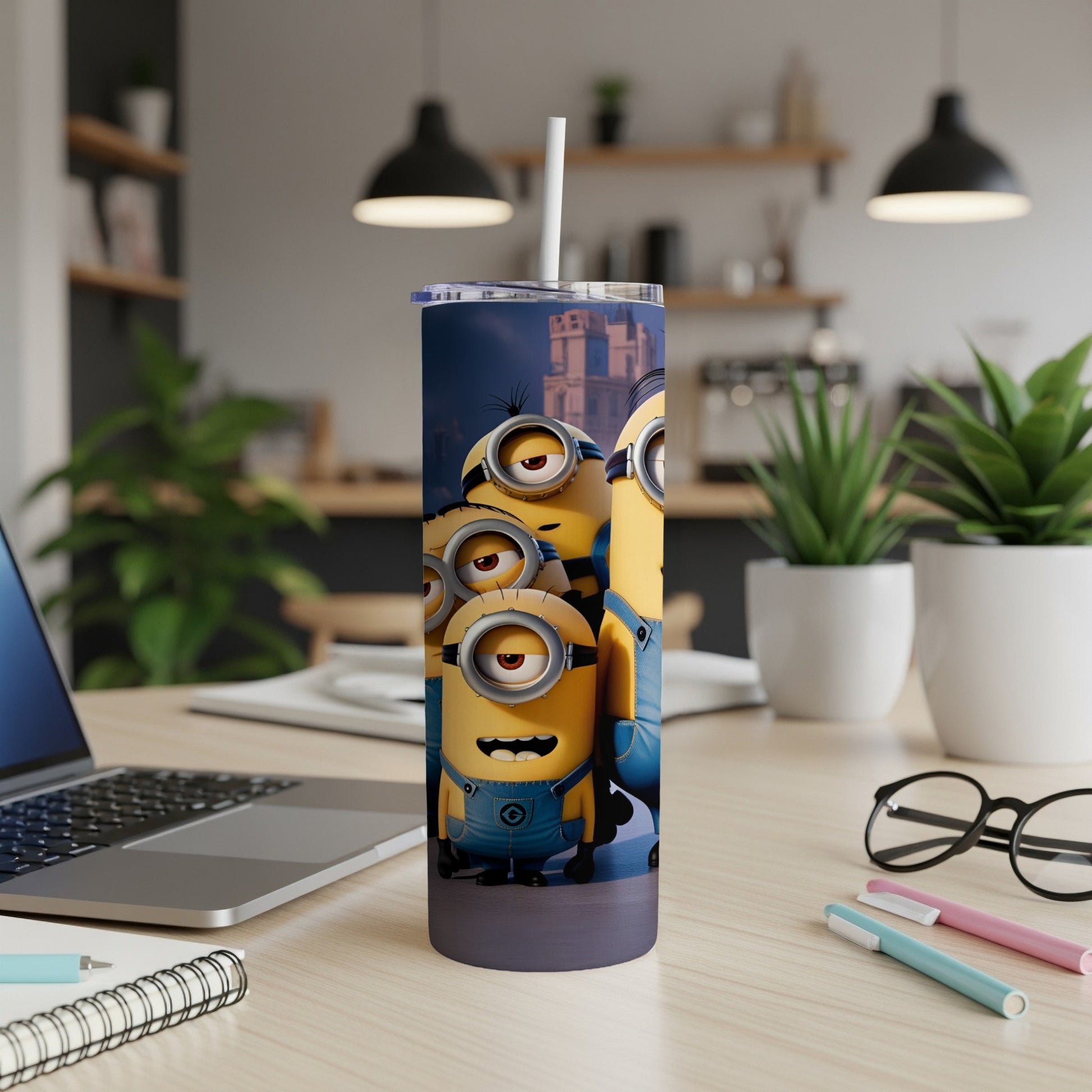 Minions characters on a blue tumbler with a straw, on a desk.