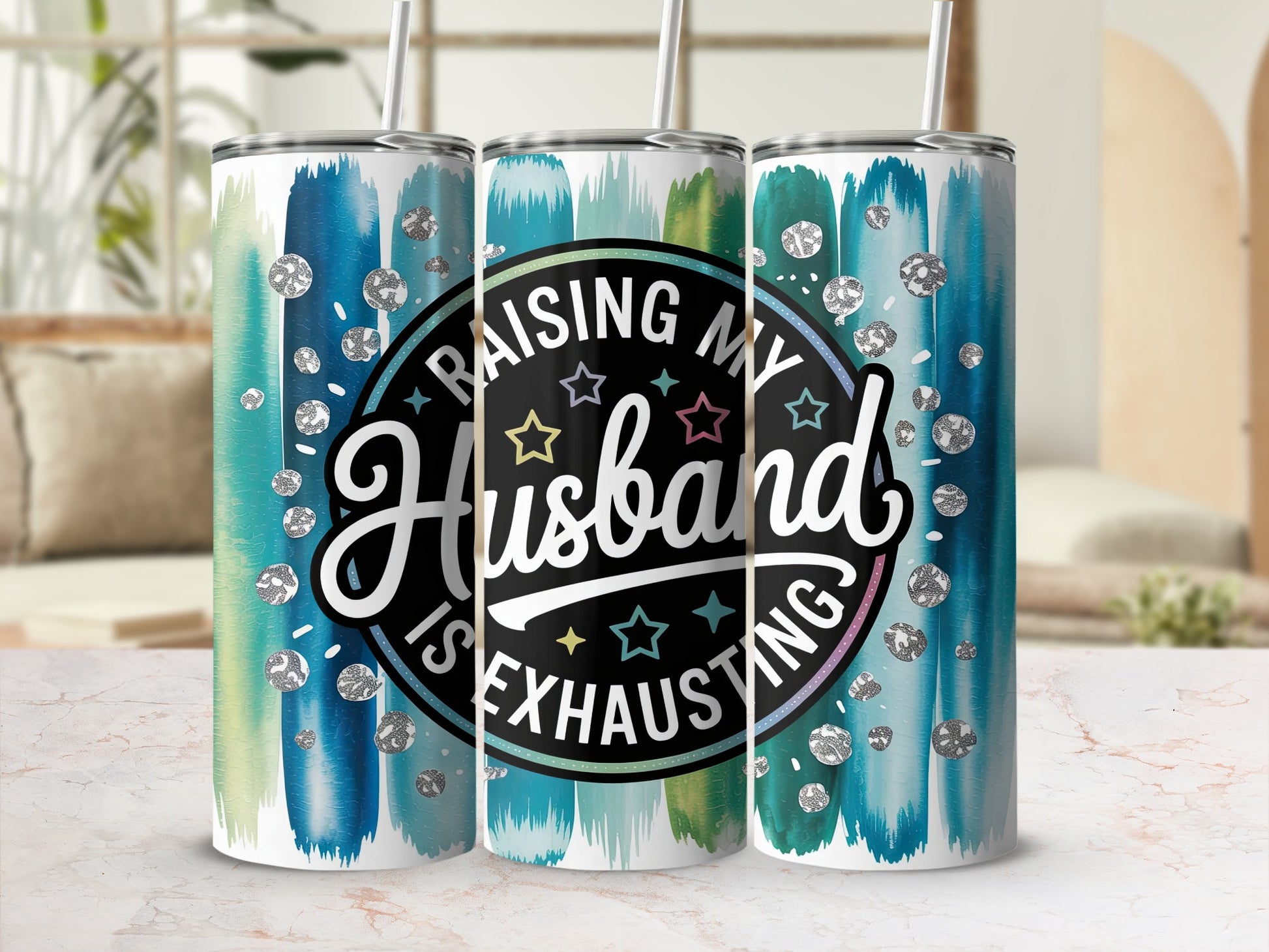 Tumbler with colorful paint strokes and text "Raising my Husband is Exhausting".