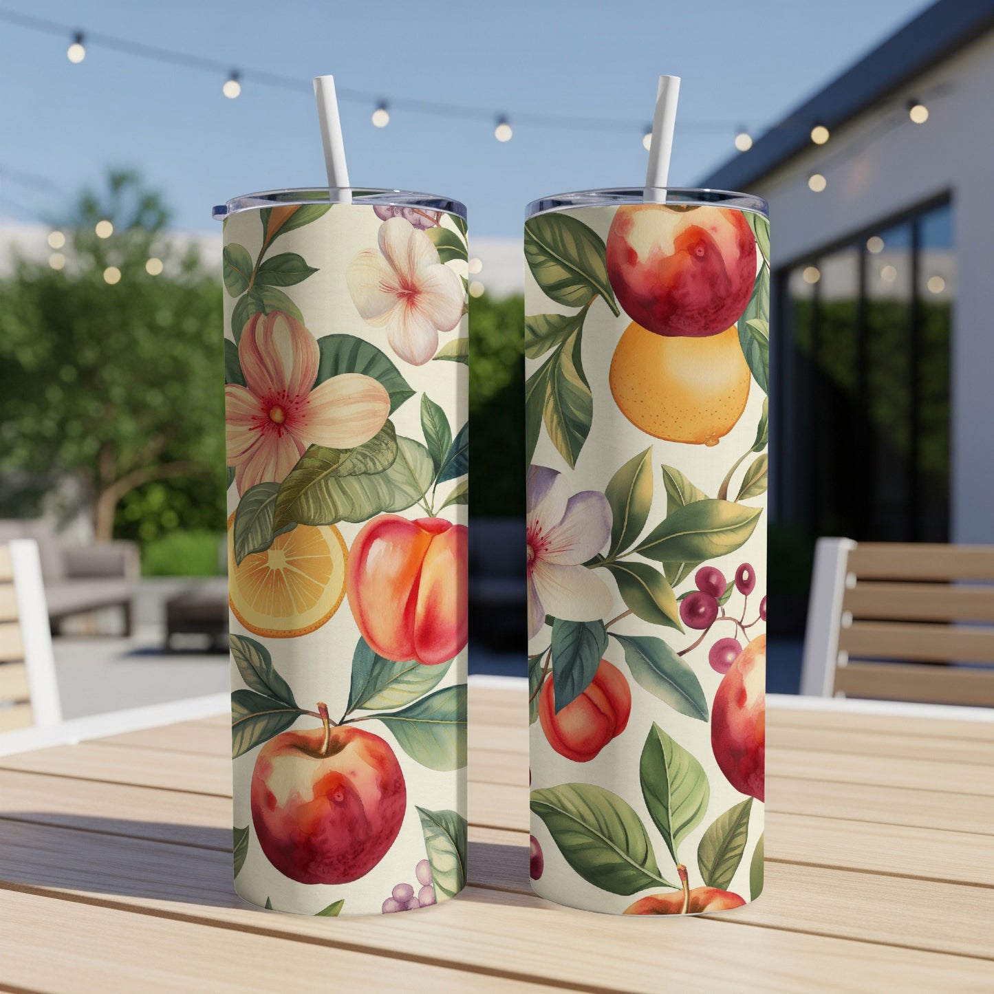 Two tumblers with a floral and fruit pattern, resting on a wooden table.