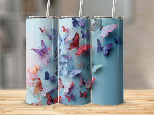 Three tumblers with vibrant butterfly designs on a wooden surface.