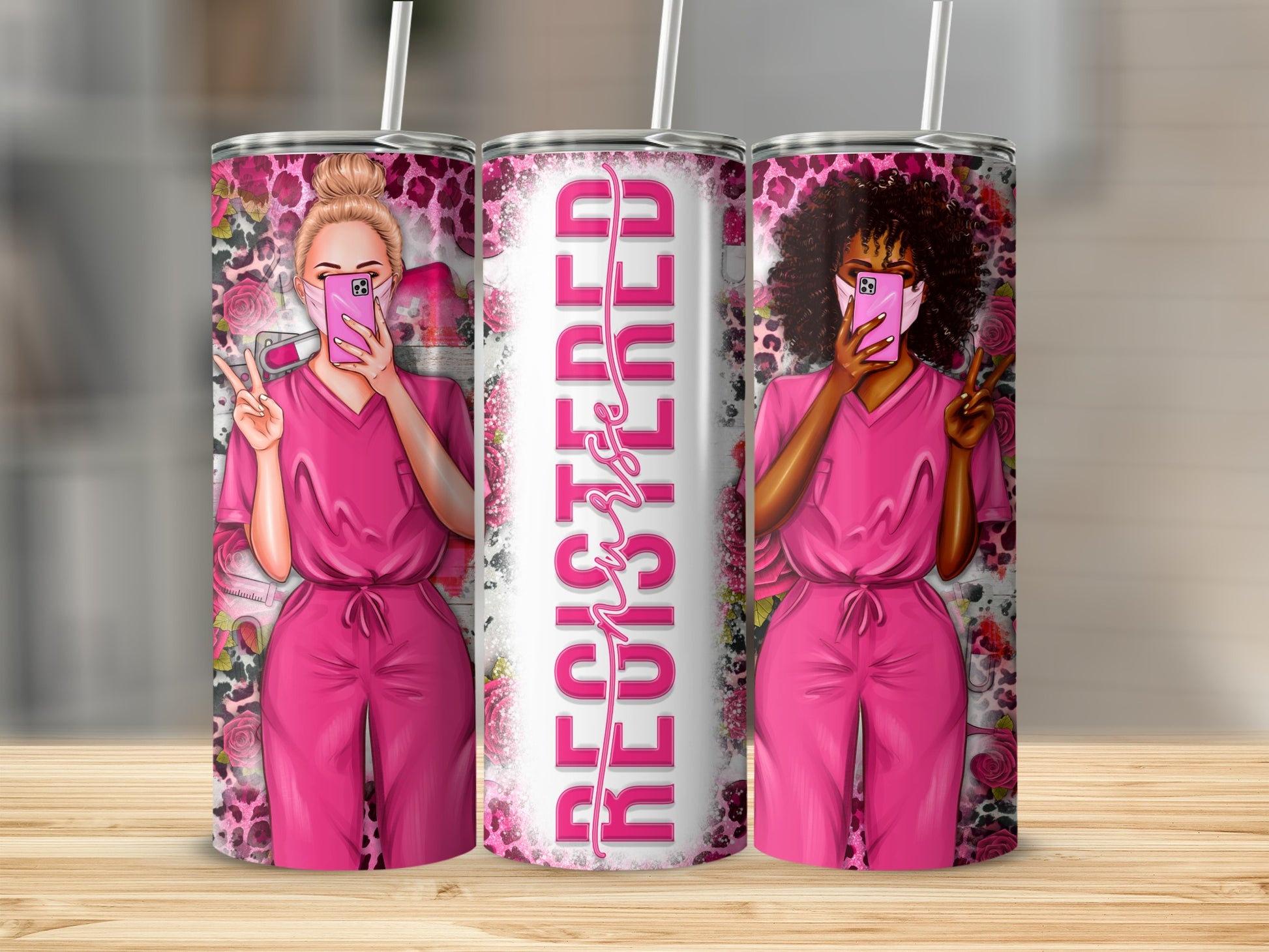 Two nurses in pink scrubs, one with blonde hair, one with dark curly hair, hold up a phone and peace sign.