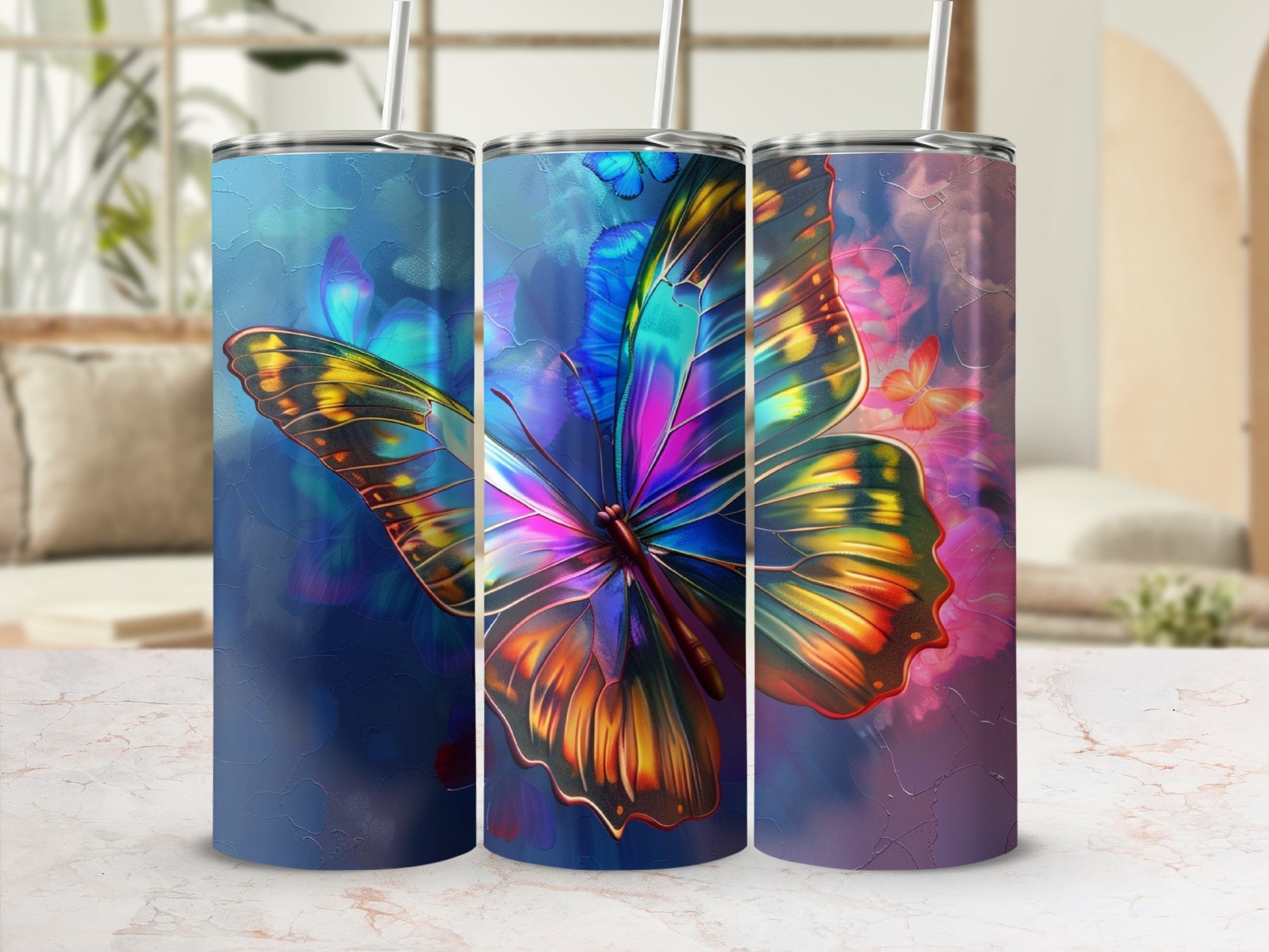 Three tumblers with vibrant butterfly designs on a table.