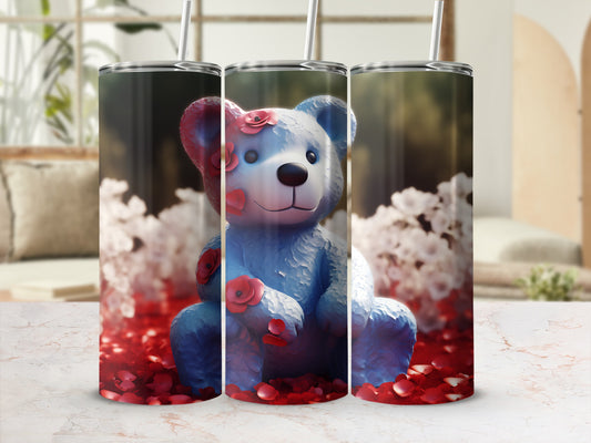 Blue teddy bear with red flowers sits amongst rose petals.