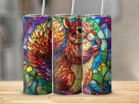 Stained glass tumbler featuring a squirrel with colorful feathers and a brick background.