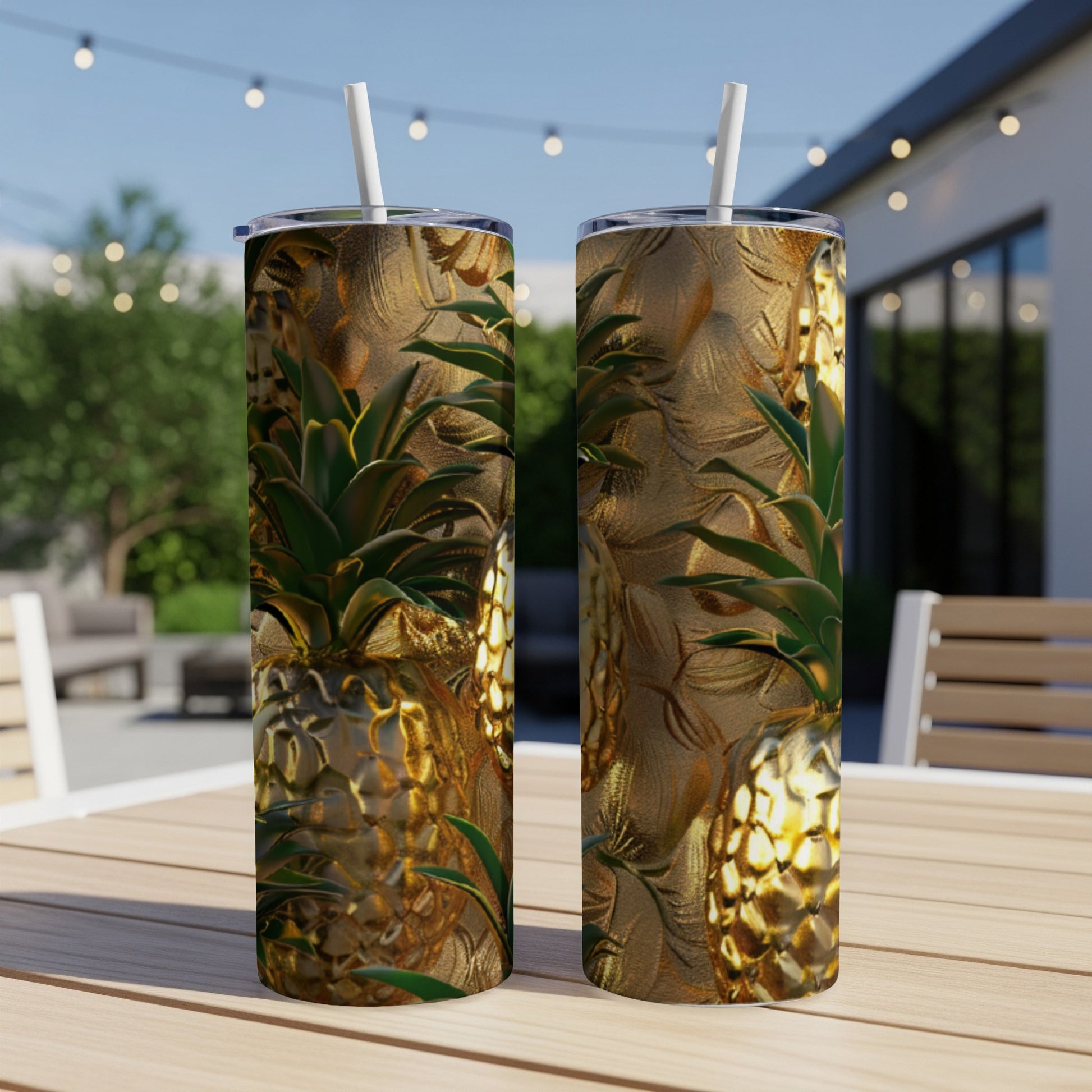 Two gold pineapples on a textured tumbler, with a straw.