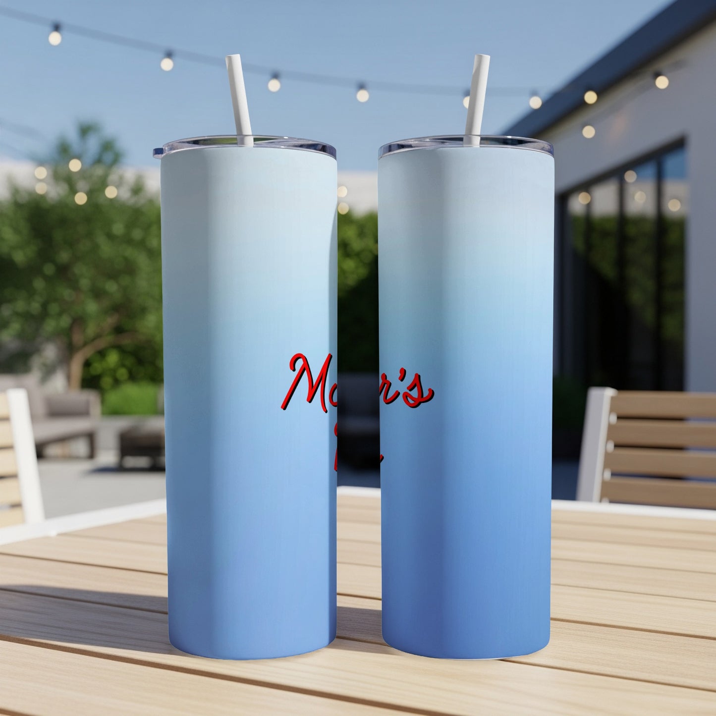 Two blue gradient tumblers with "Mom's" text on a table.