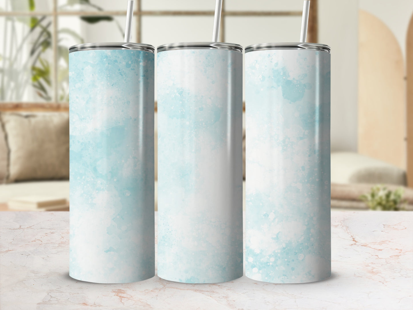 Three light blue watercolor tumblers with straws on a marble surface.