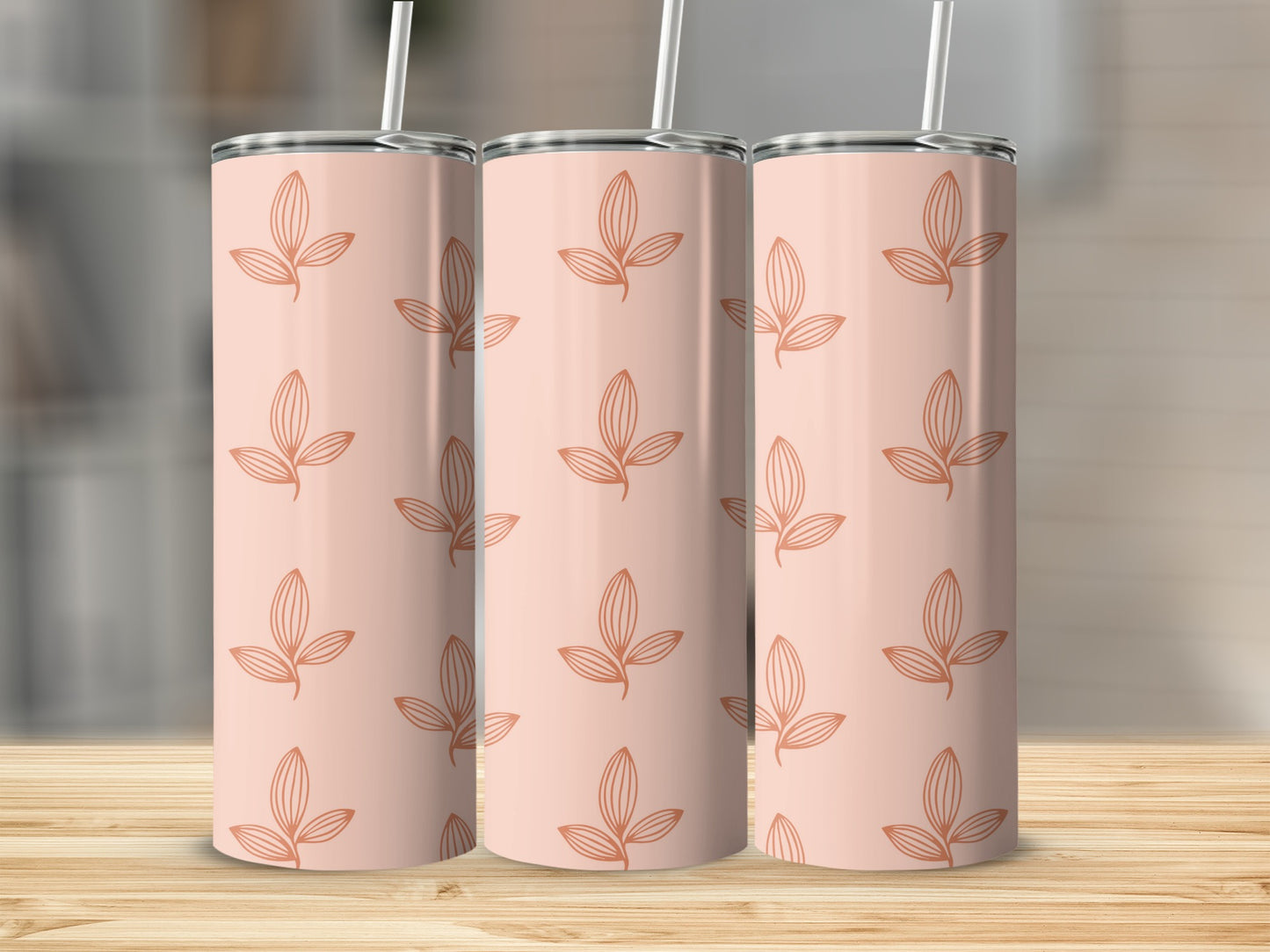Three rose gold tumblers with a repeating leaf pattern.