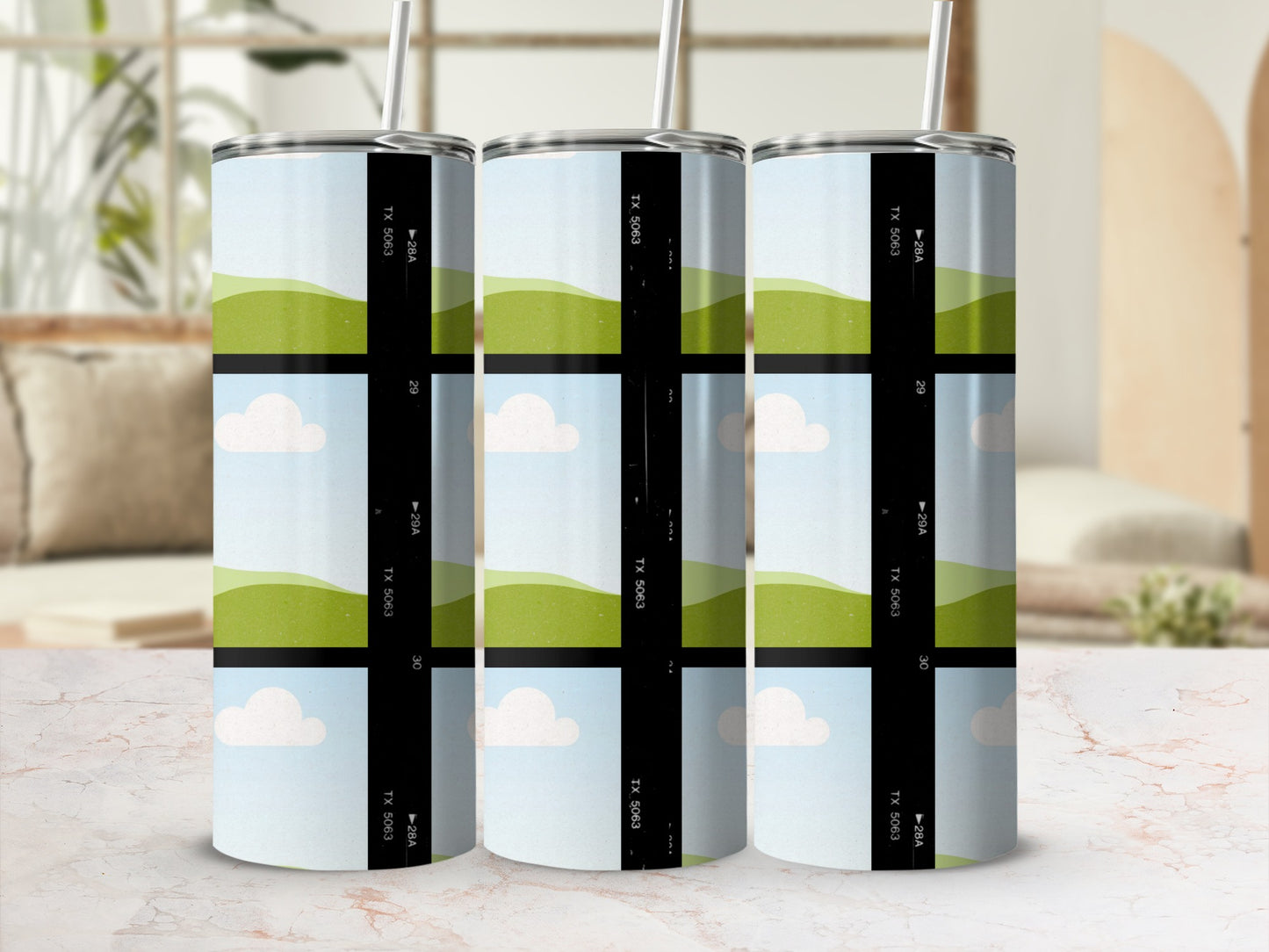 Three tumblers with a film strip design featuring rolling green hills and clouds.