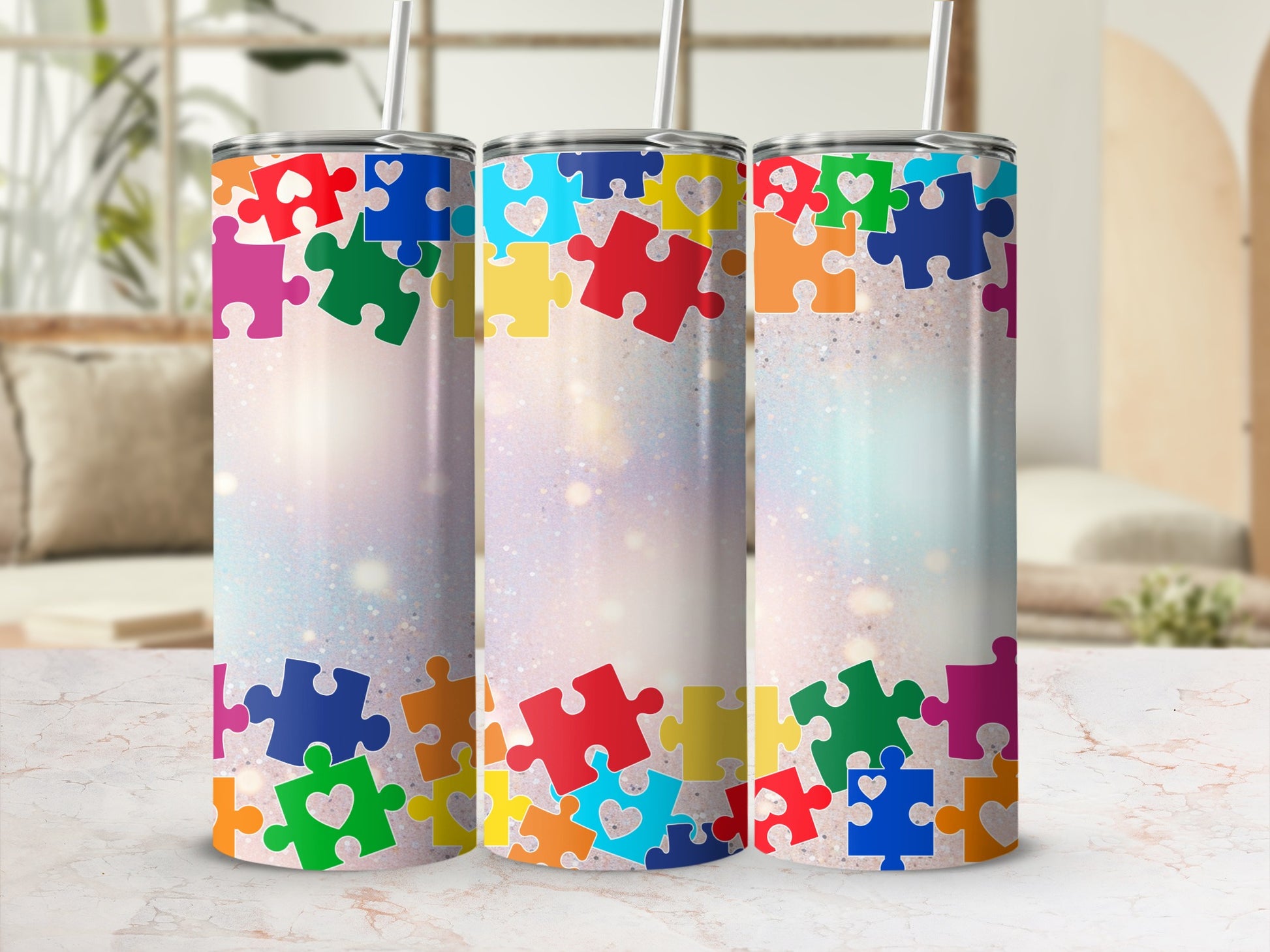 Three tall tumblers decorated with colorful puzzle pieces and glitter accents.
