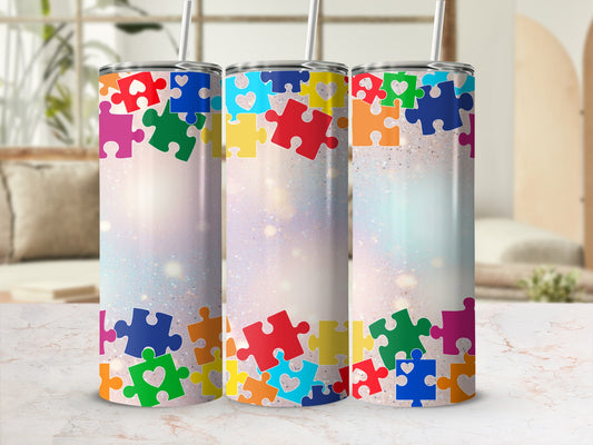 Three tall tumblers decorated with colorful puzzle pieces and glitter accents.