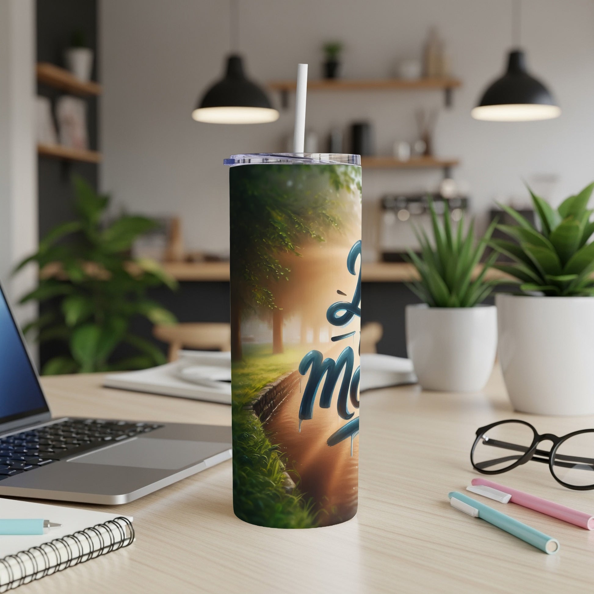 "Love More" tumbler with a serene nature scene and sunlight.