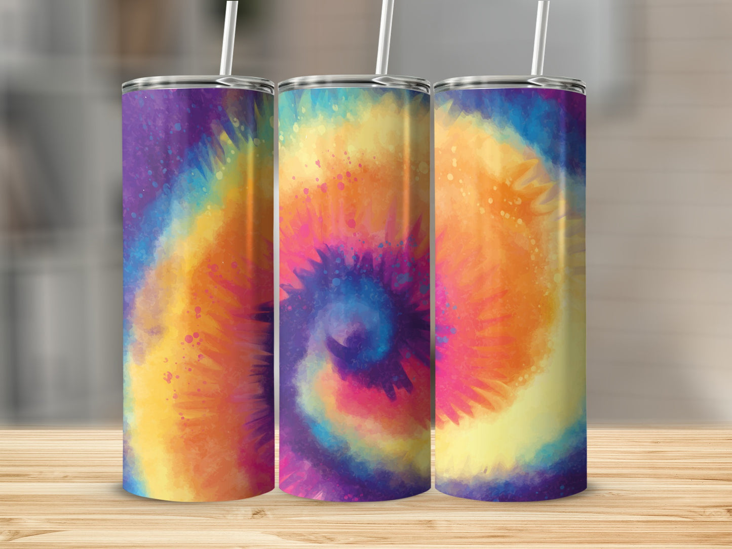 Three tumblers with colorful tie-dye patterns and straws on a wooden surface.