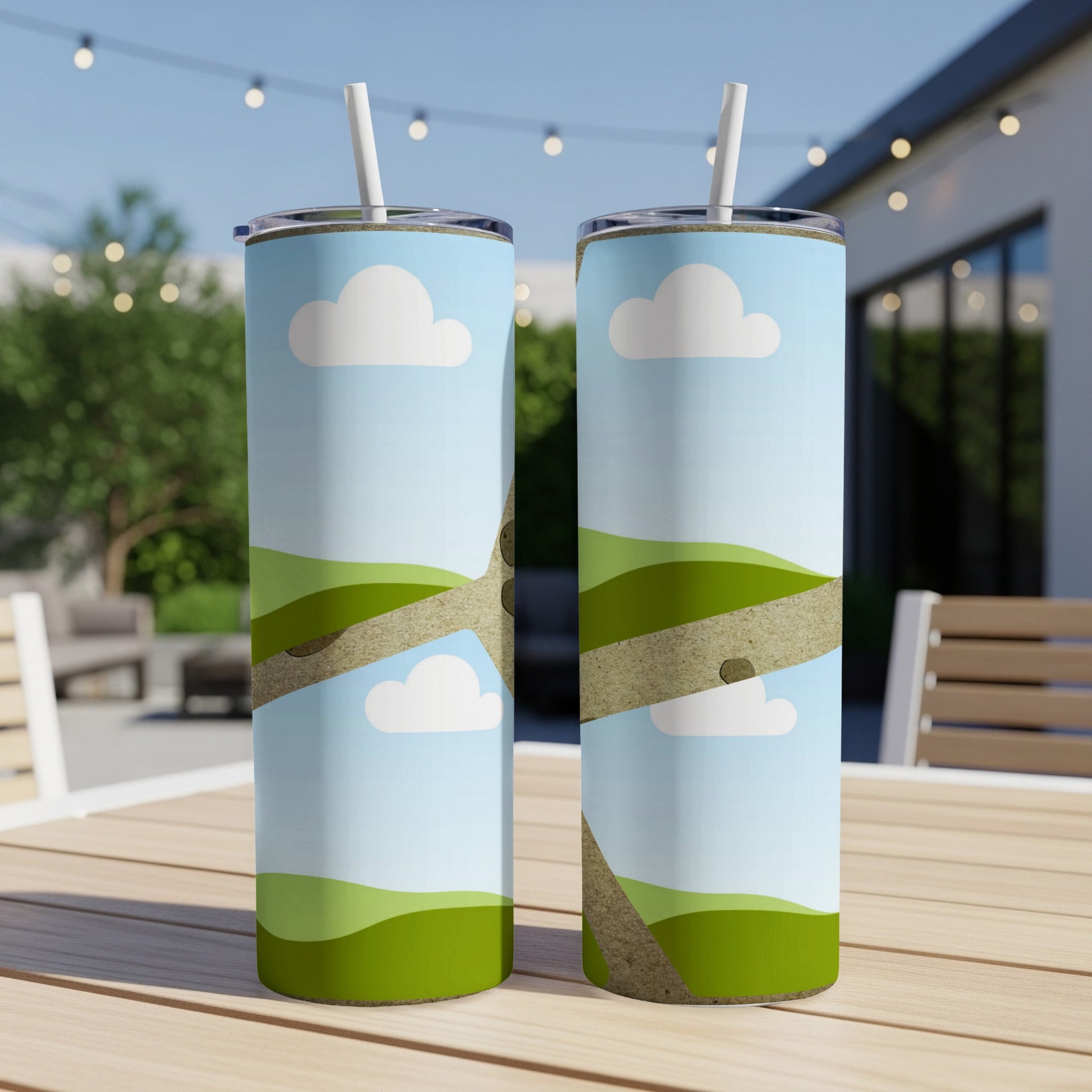 Two tumblers with a cartoon landscape design of green hills and clouds.