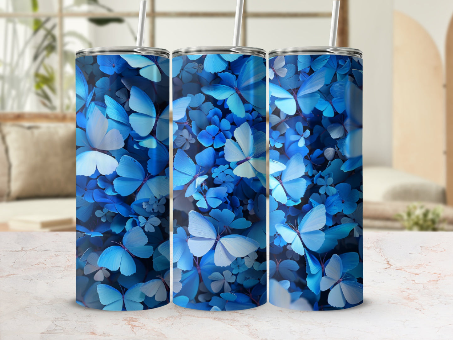 Blue butterflies and foliage pattern on three tumblers with straws.