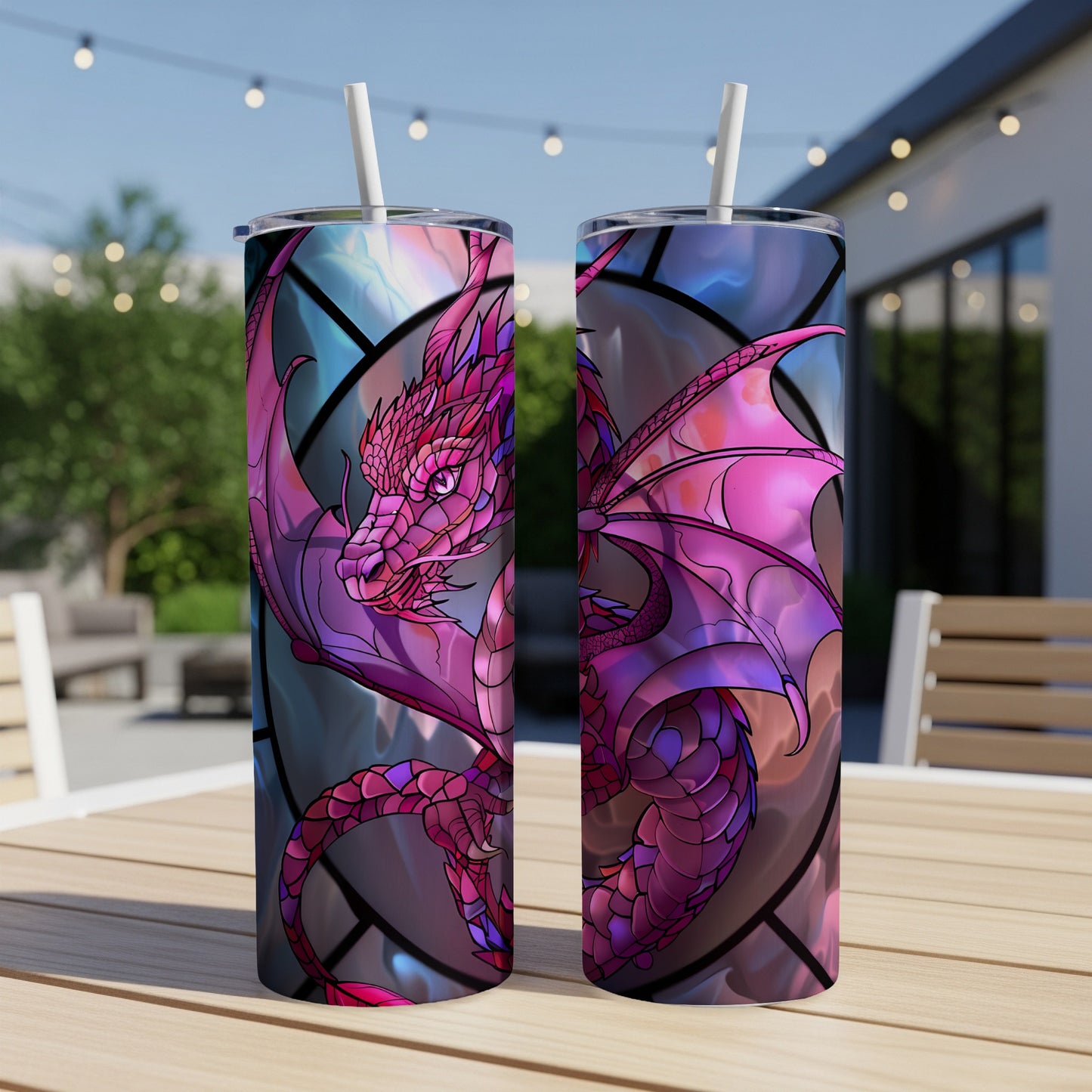 Two stained-glass dragon tumblers with straws on a table.