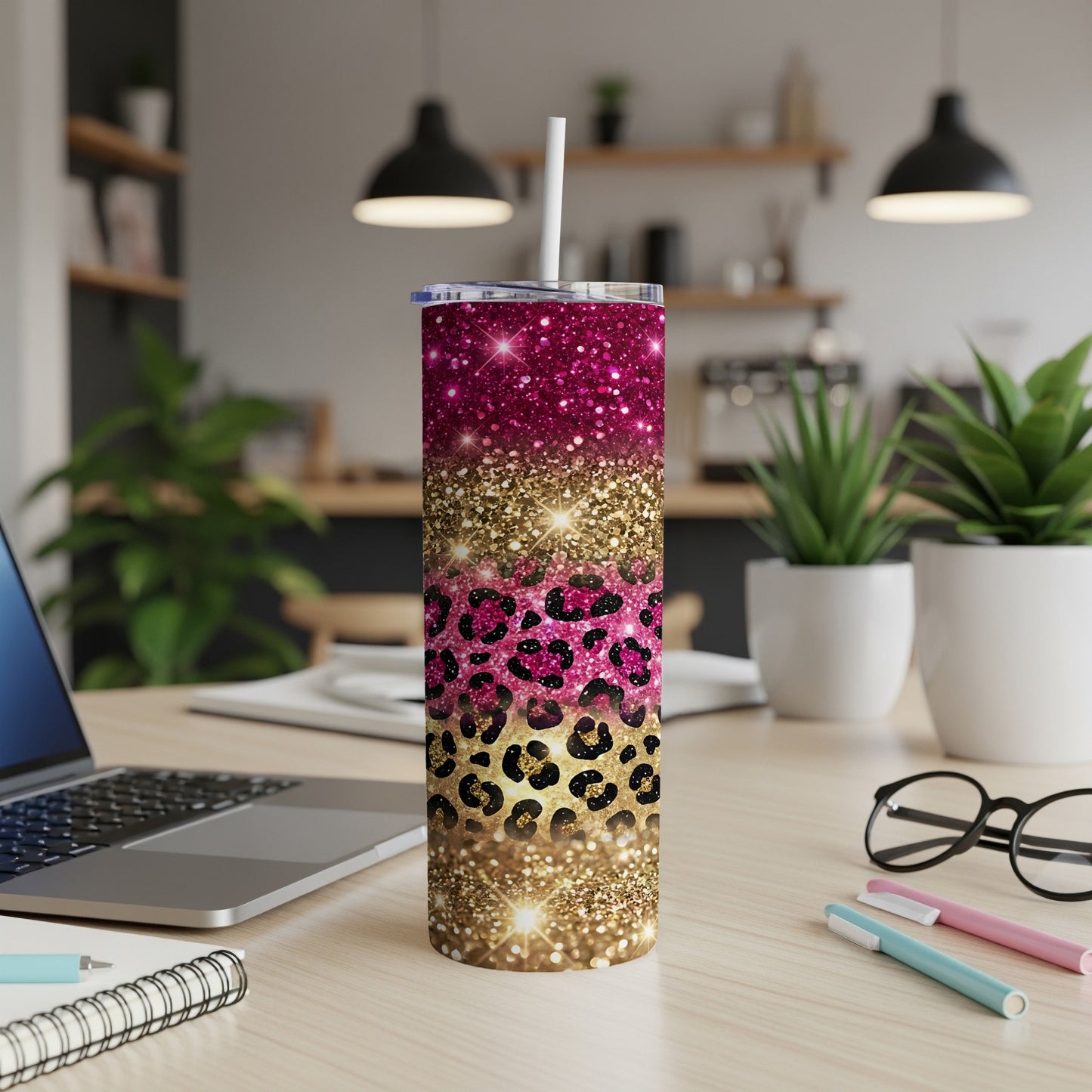Glittery pink leopard print tumbler with straw on desk.