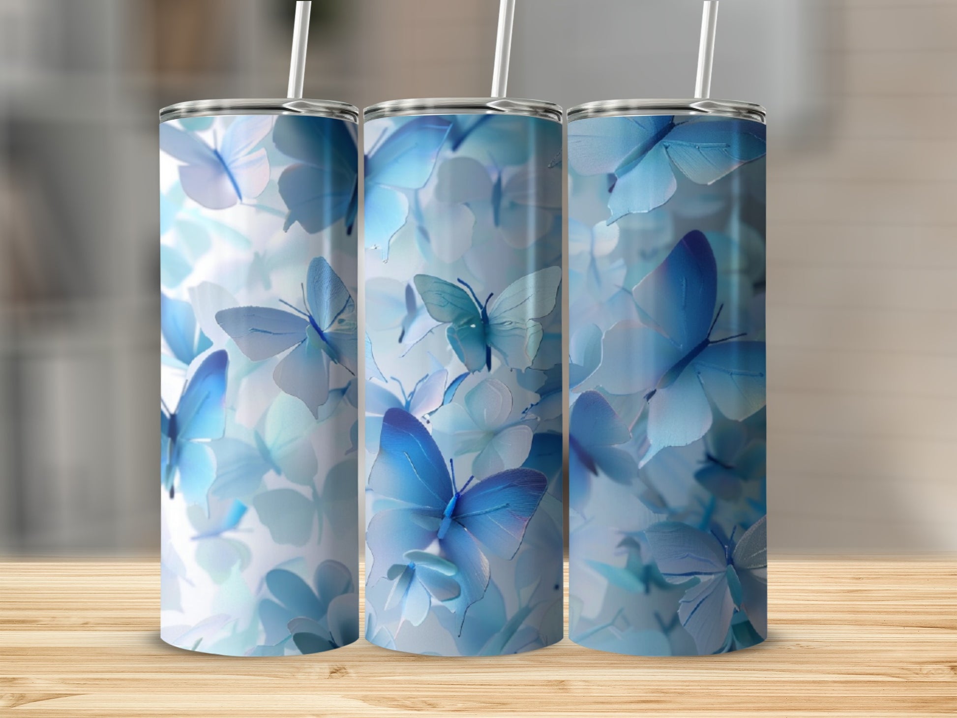 Three tumblers adorned with a pattern of blue butterflies and floral elements.