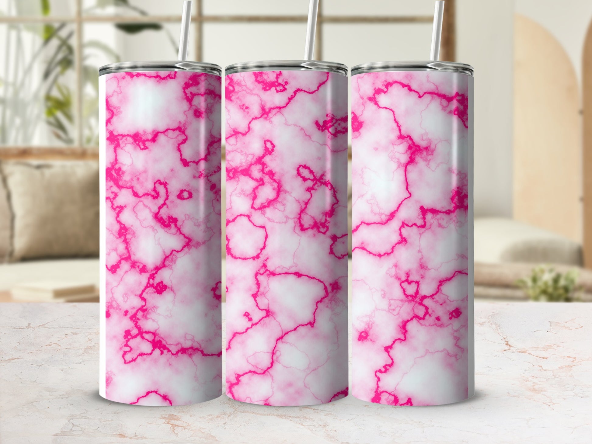 Three pink and white marble print tumblers with straws.