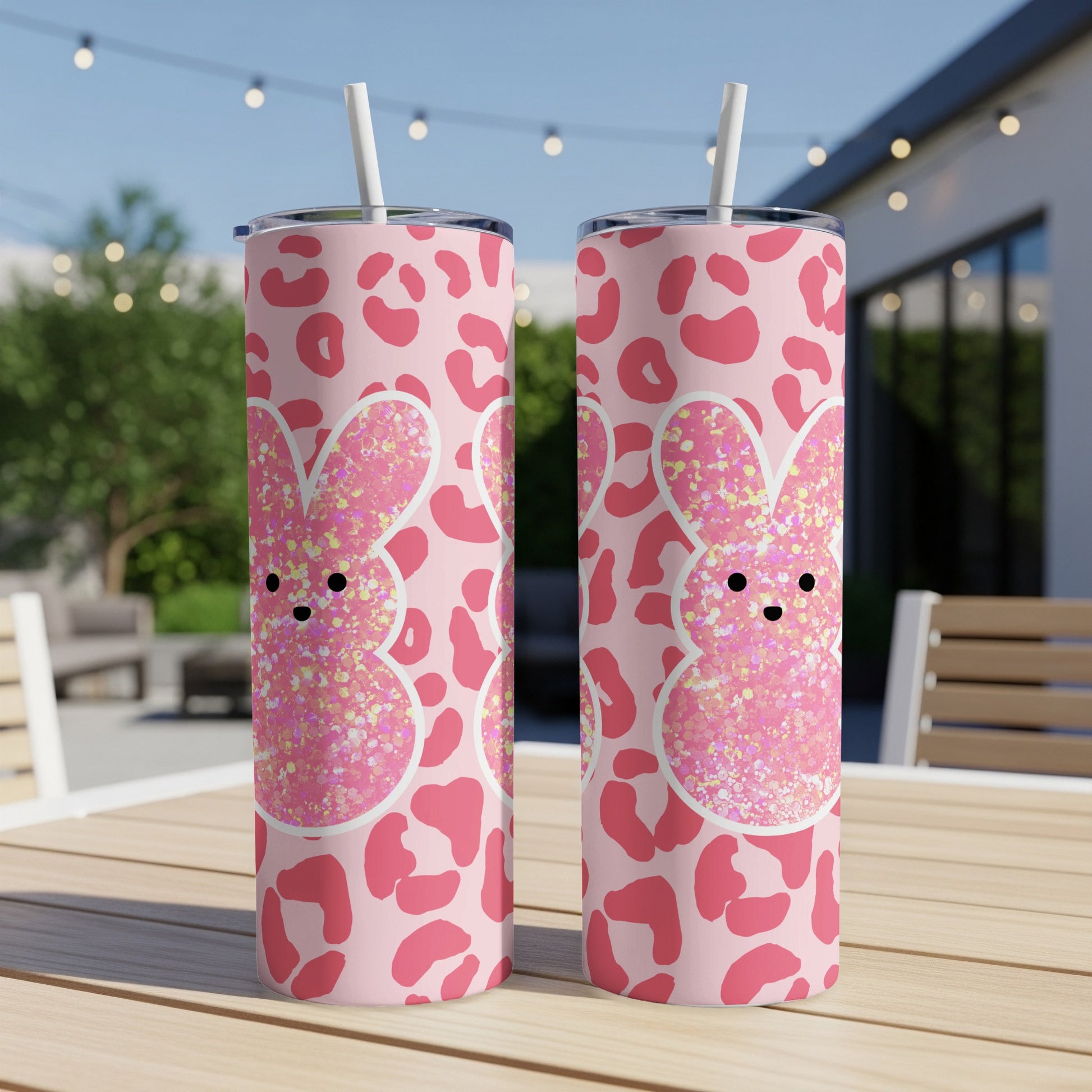 Two pink bunny tumblers with leopard print on a wooden table.