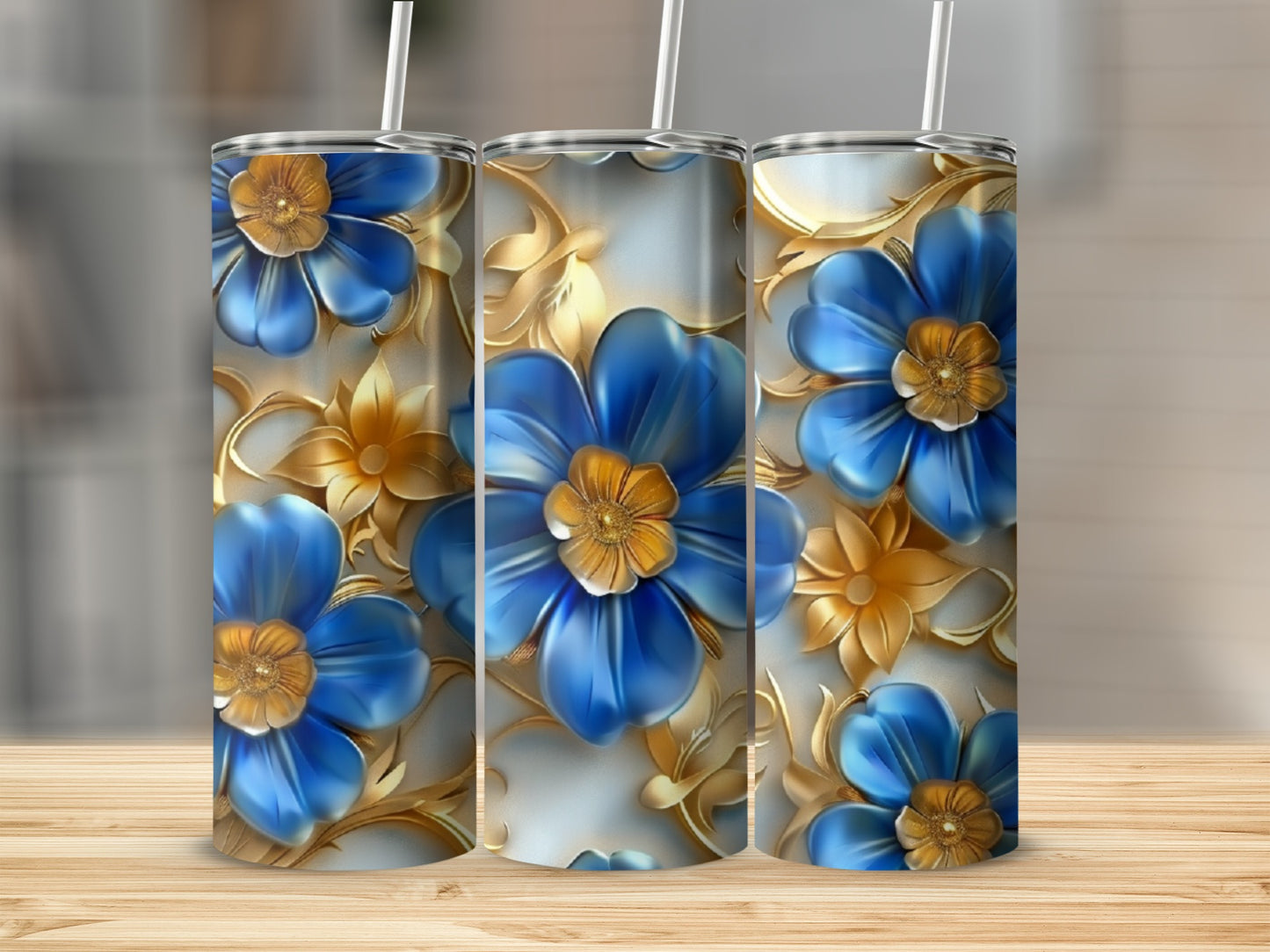 Three blue and gold floral patterned tumblers on a wooden surface.