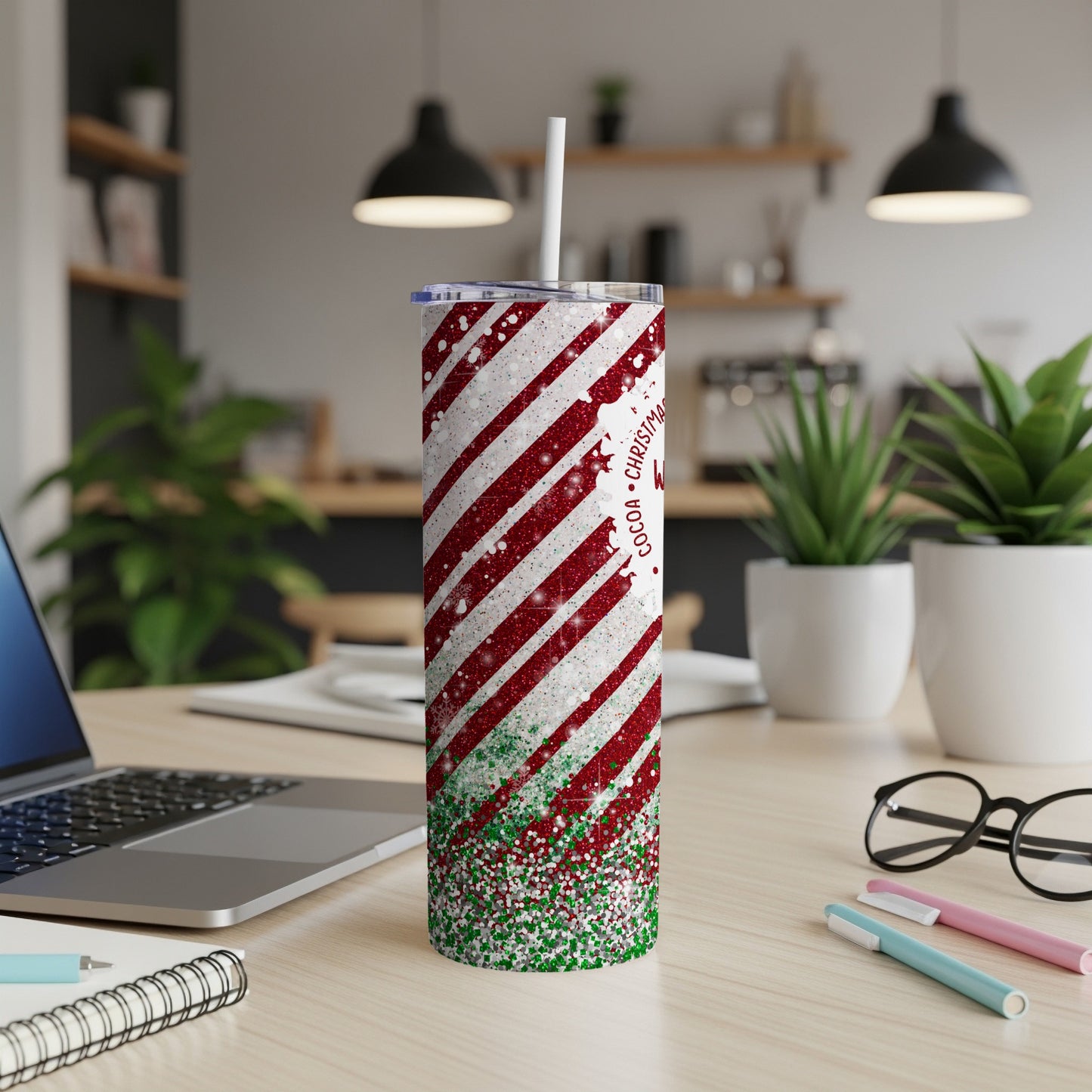 Red and white striped tumbler with green glitter details and a straw.
