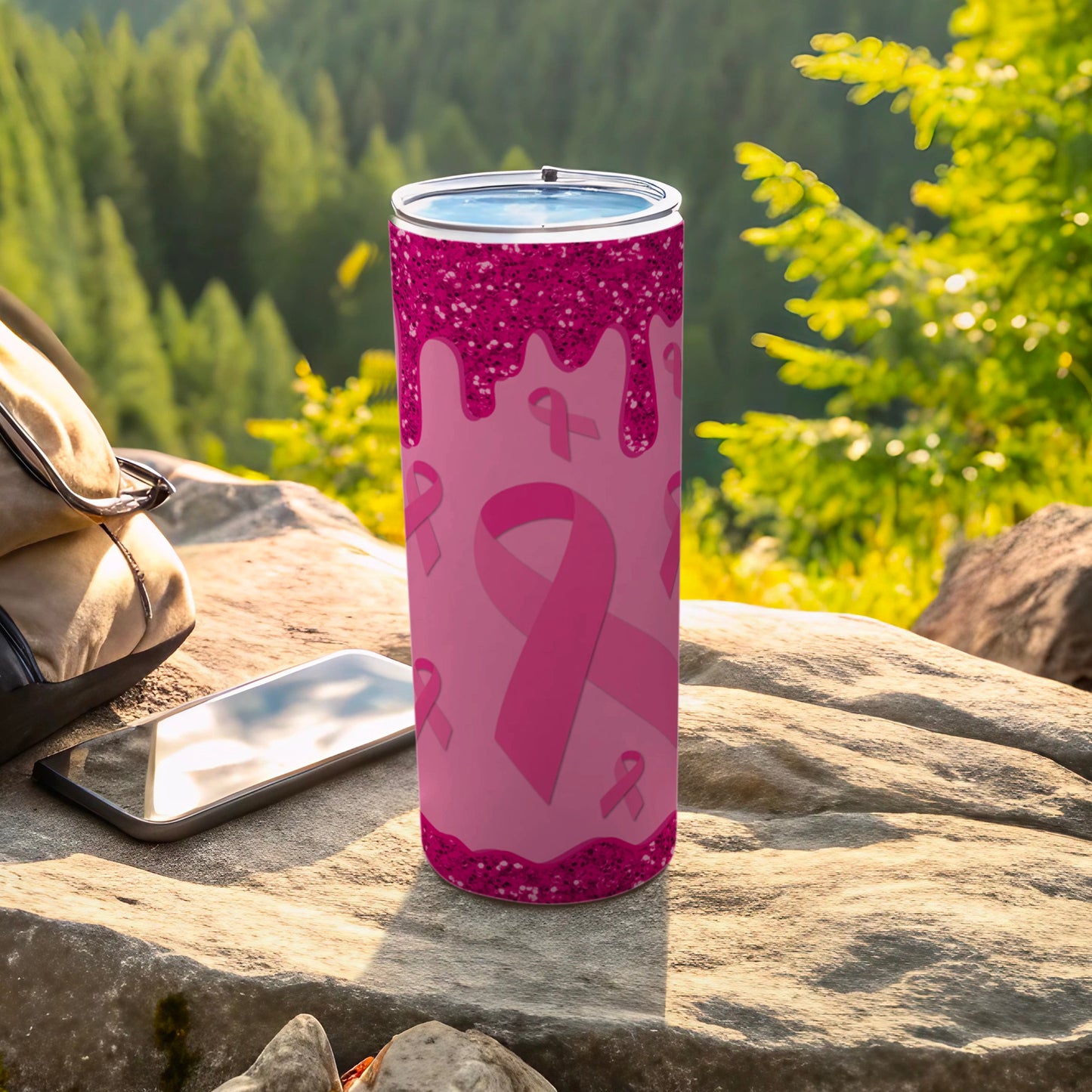 Pink tumbler with ribbon pattern, drippy design, on rocks outdoors.