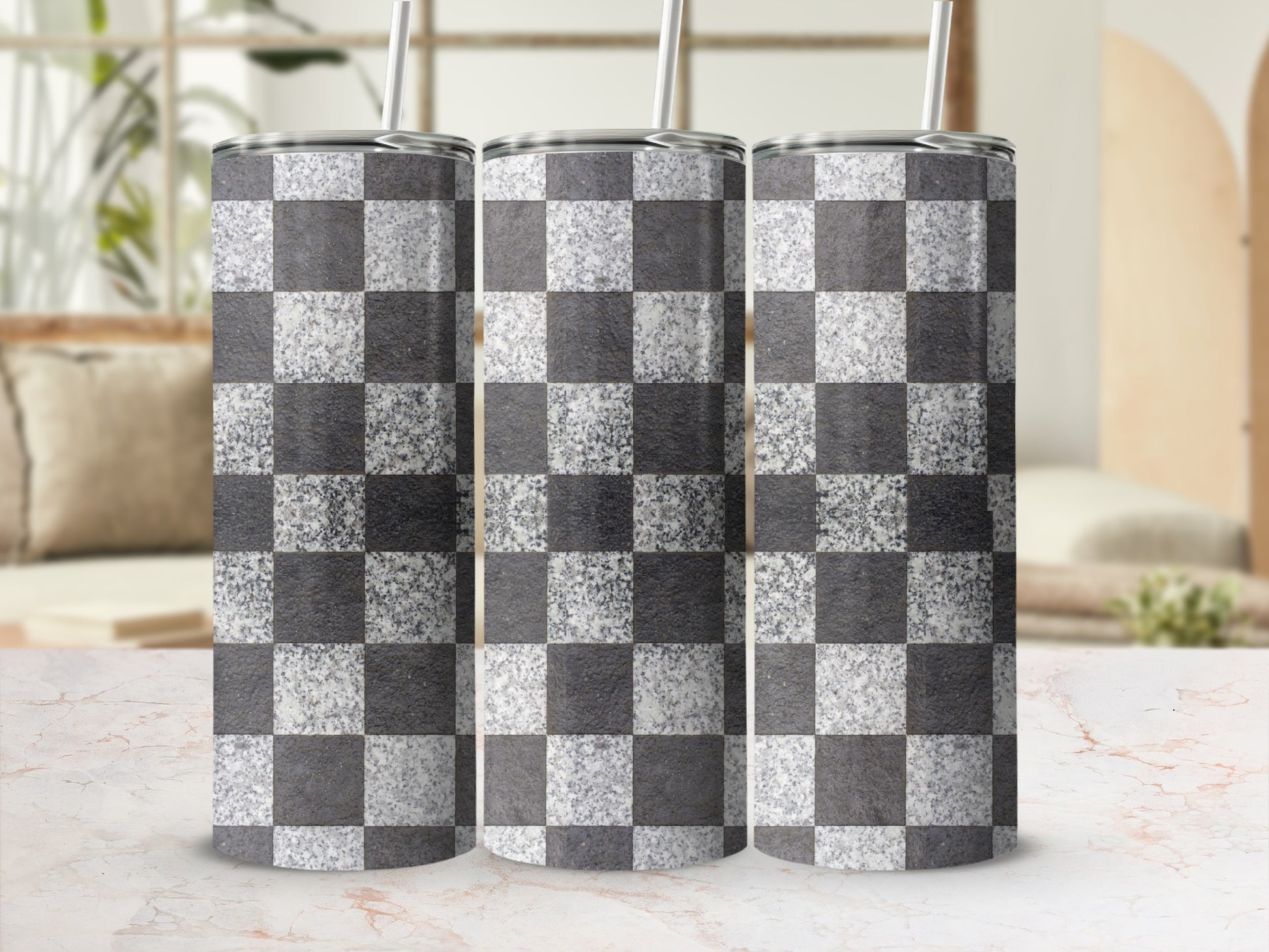 Three tumblers with a black and white checkerboard glitter pattern, against a blurred background.