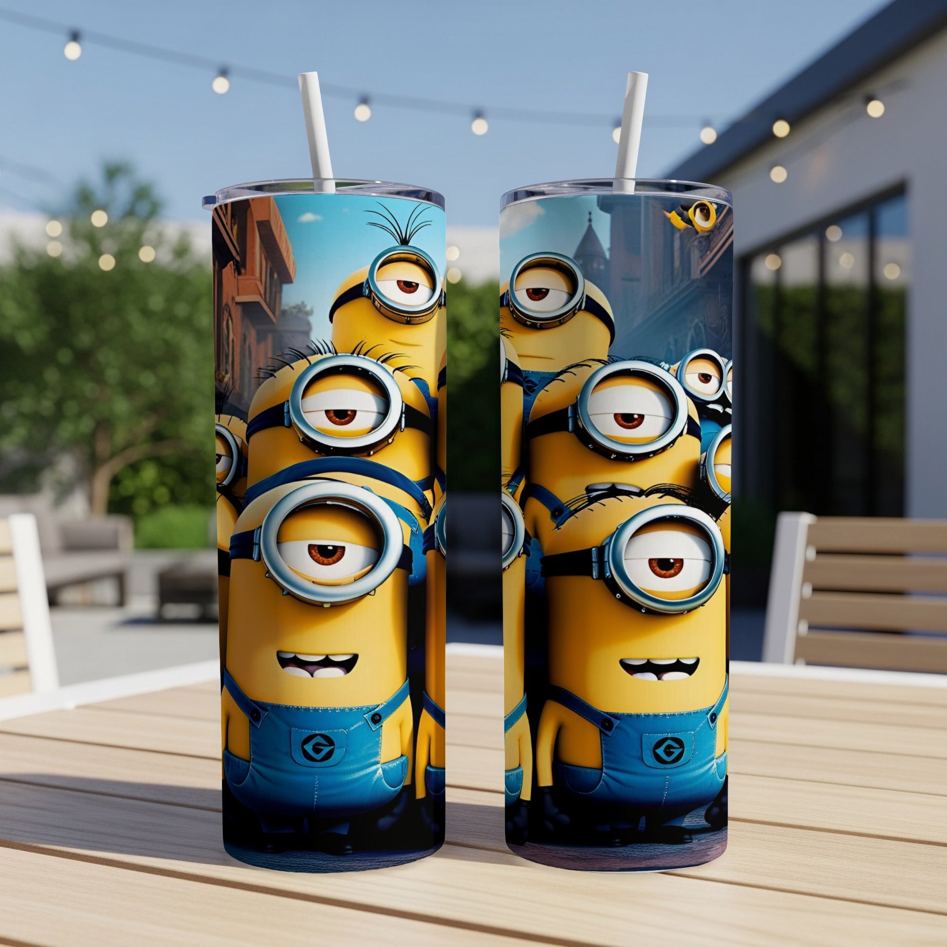 Two Minions travel tumblers with straws stand on a wooden table.