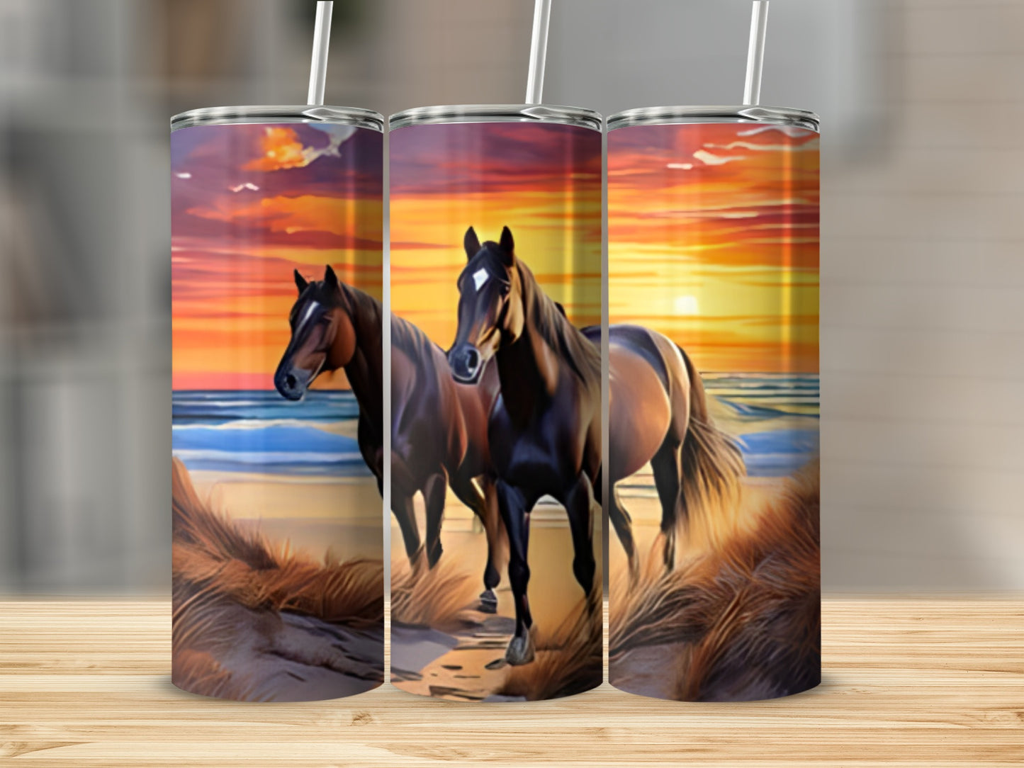 Two horses on a beach at sunset, depicted on three tumblers.
