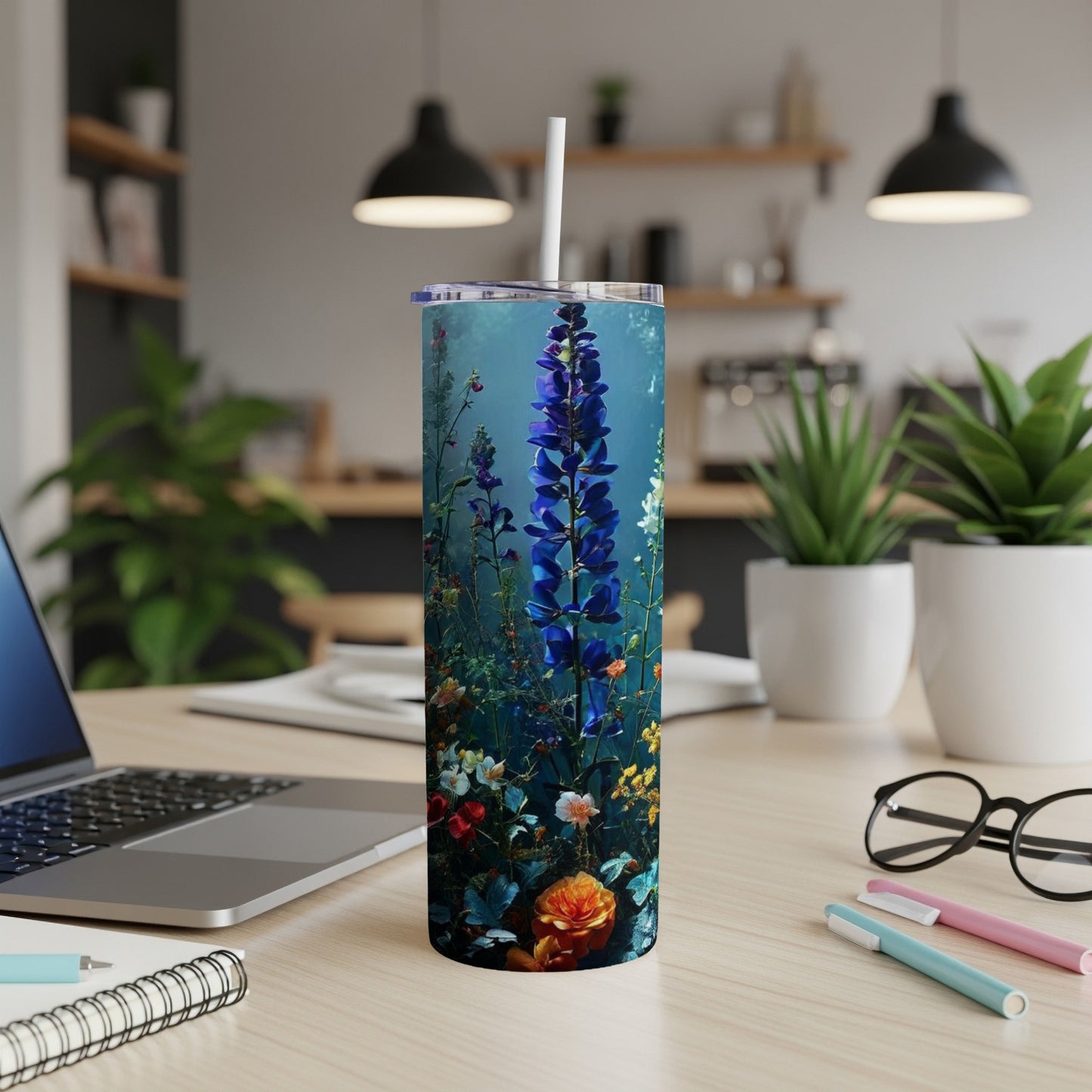 Tall tumbler with a blue flower and floral design.