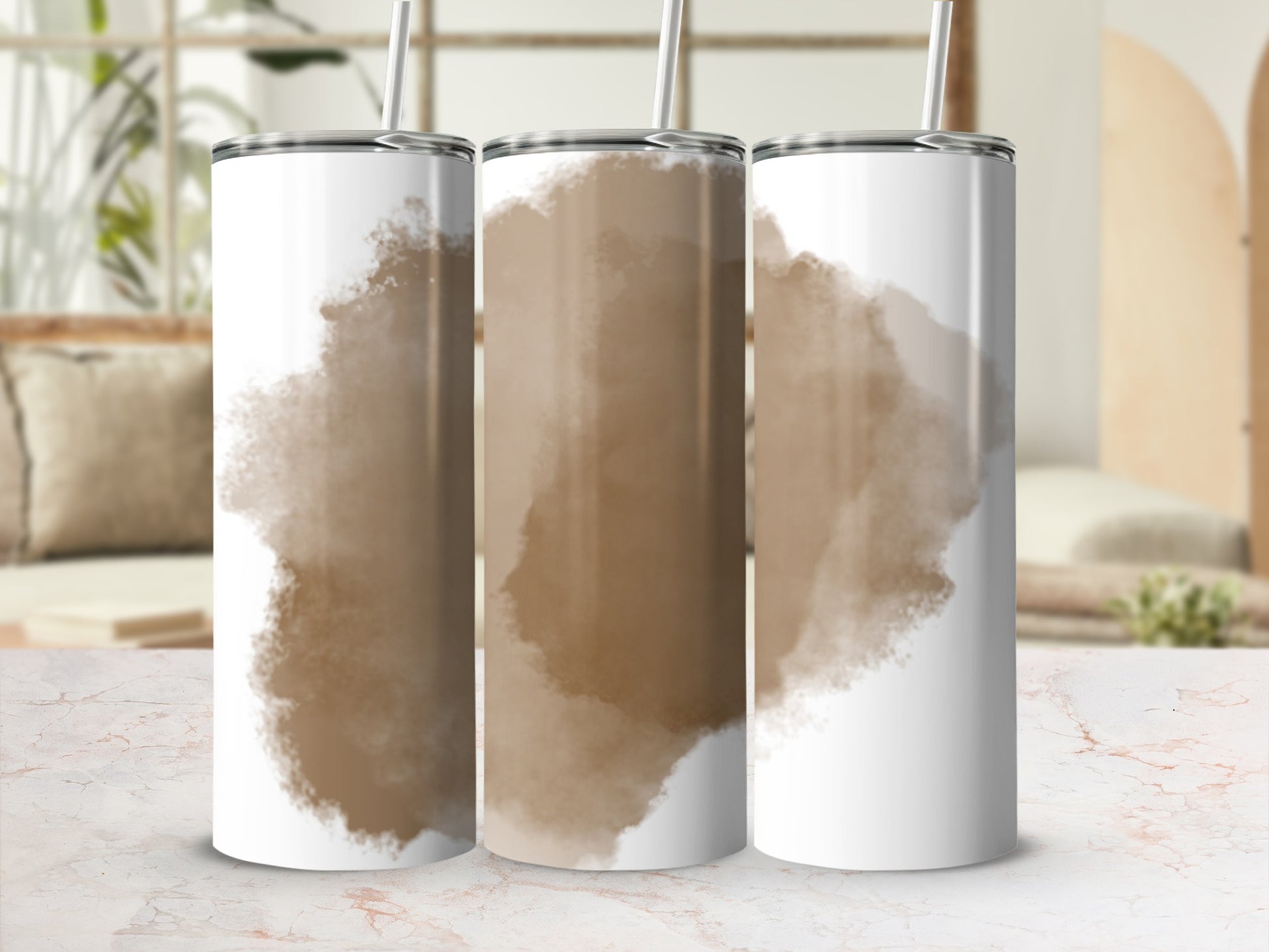 Three tumblers with abstract brown watercolor designs on a marbled surface.