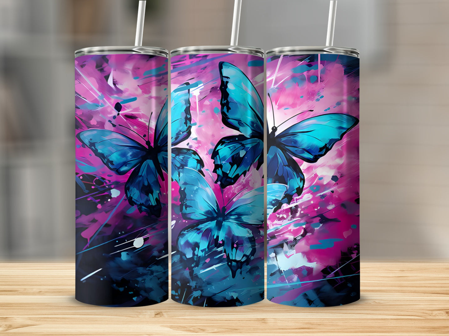 Three tumblers with a vibrant blue butterfly design on a wooden surface.