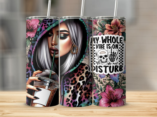 Woman with leopard hoodie and coffee, holding tumbler with skull and text.