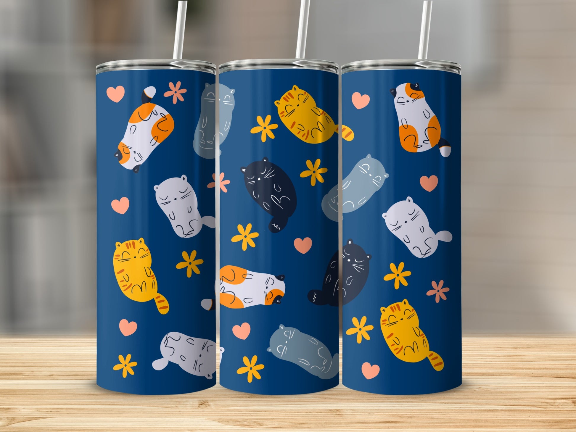 Three blue tumblers with repeating cartoon cat and flower pattern.