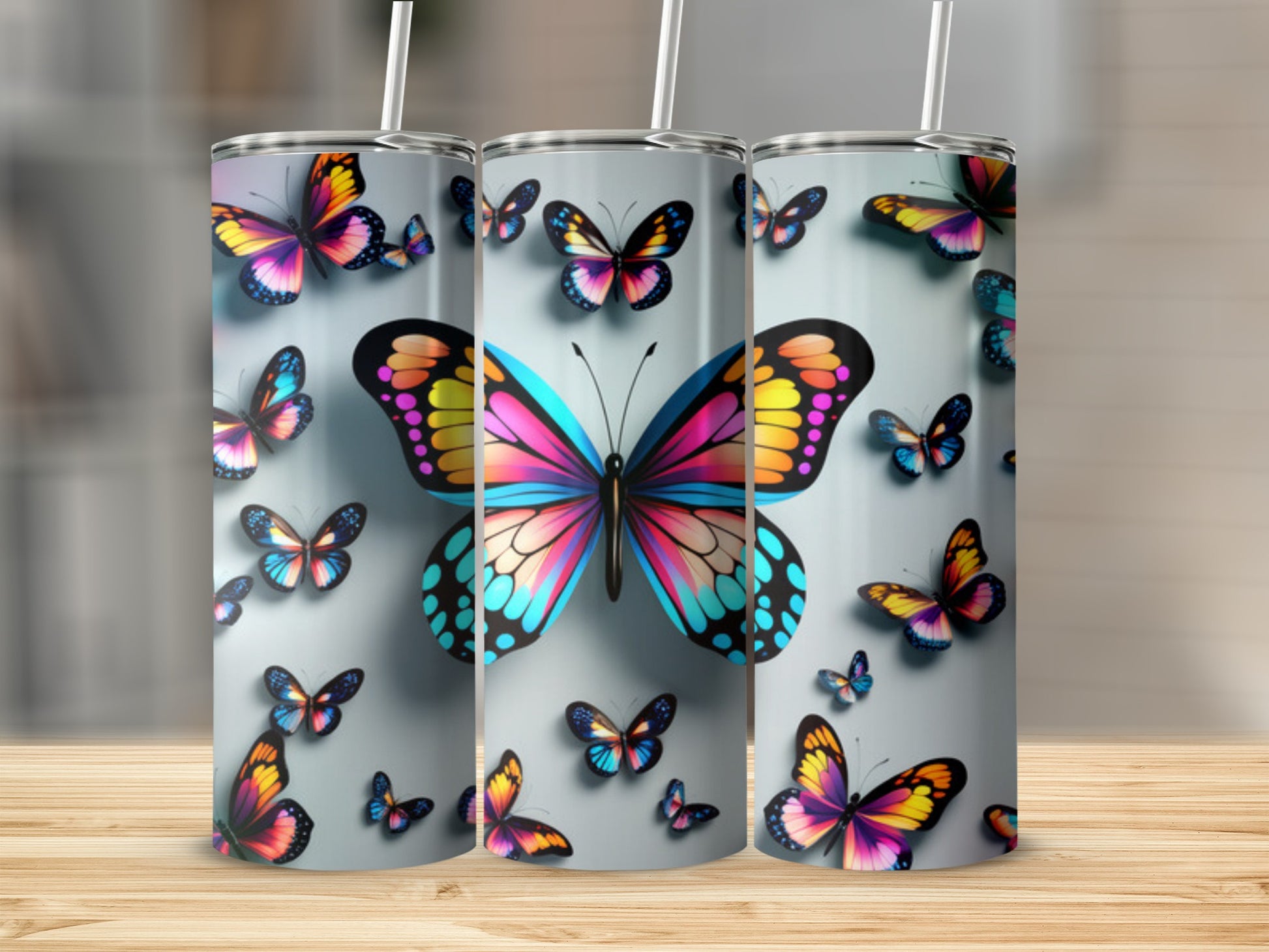 Three tumblers decorated with colorful butterfly designs.