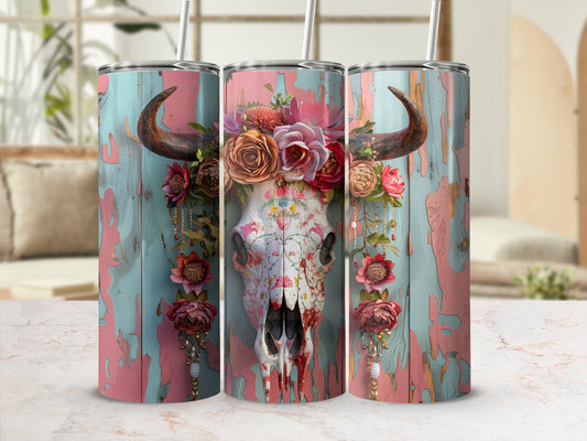 Floral skull tumbler with textured wood background and straw.