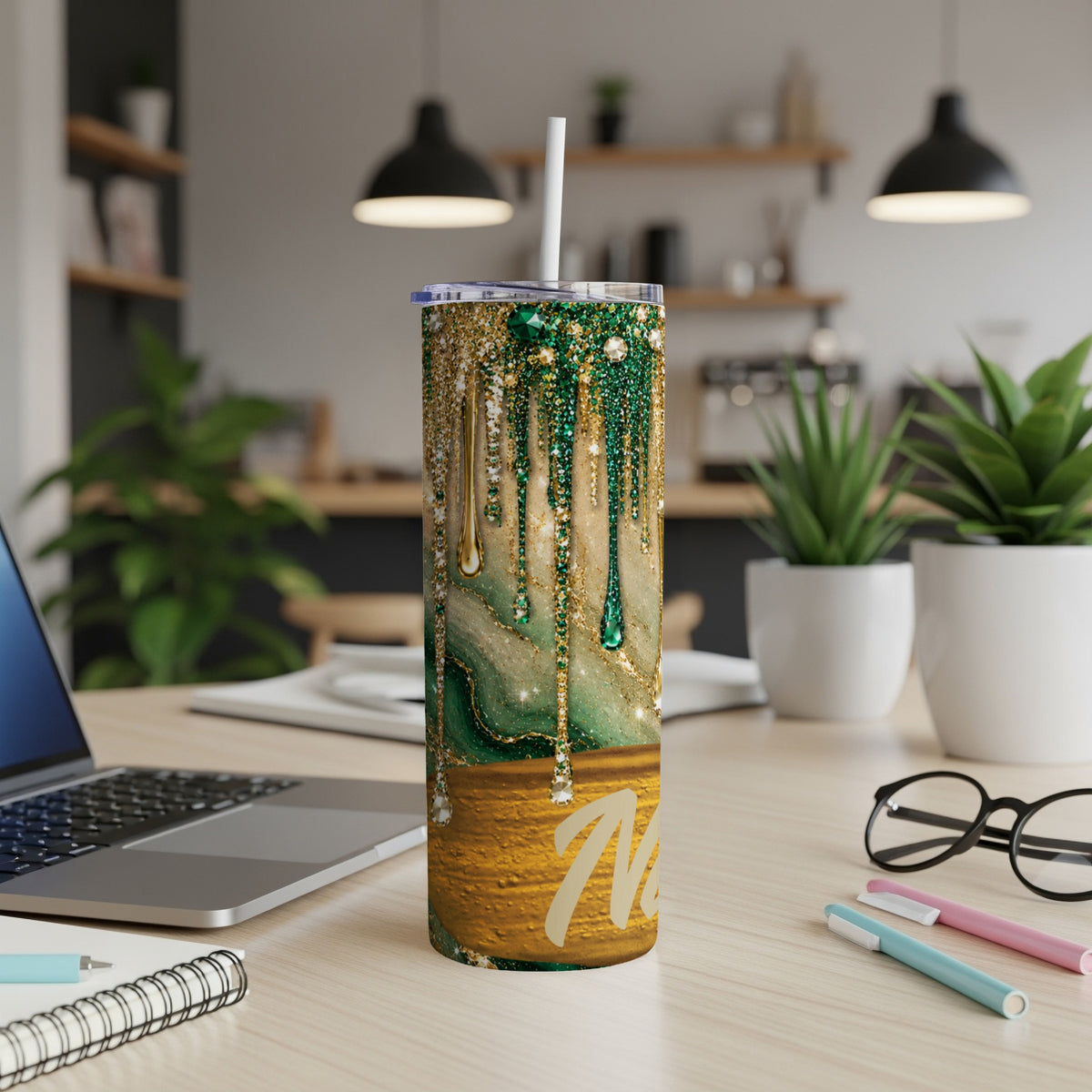 Glittering emerald green and gold marble tumbler with a straw and "M" personalization.