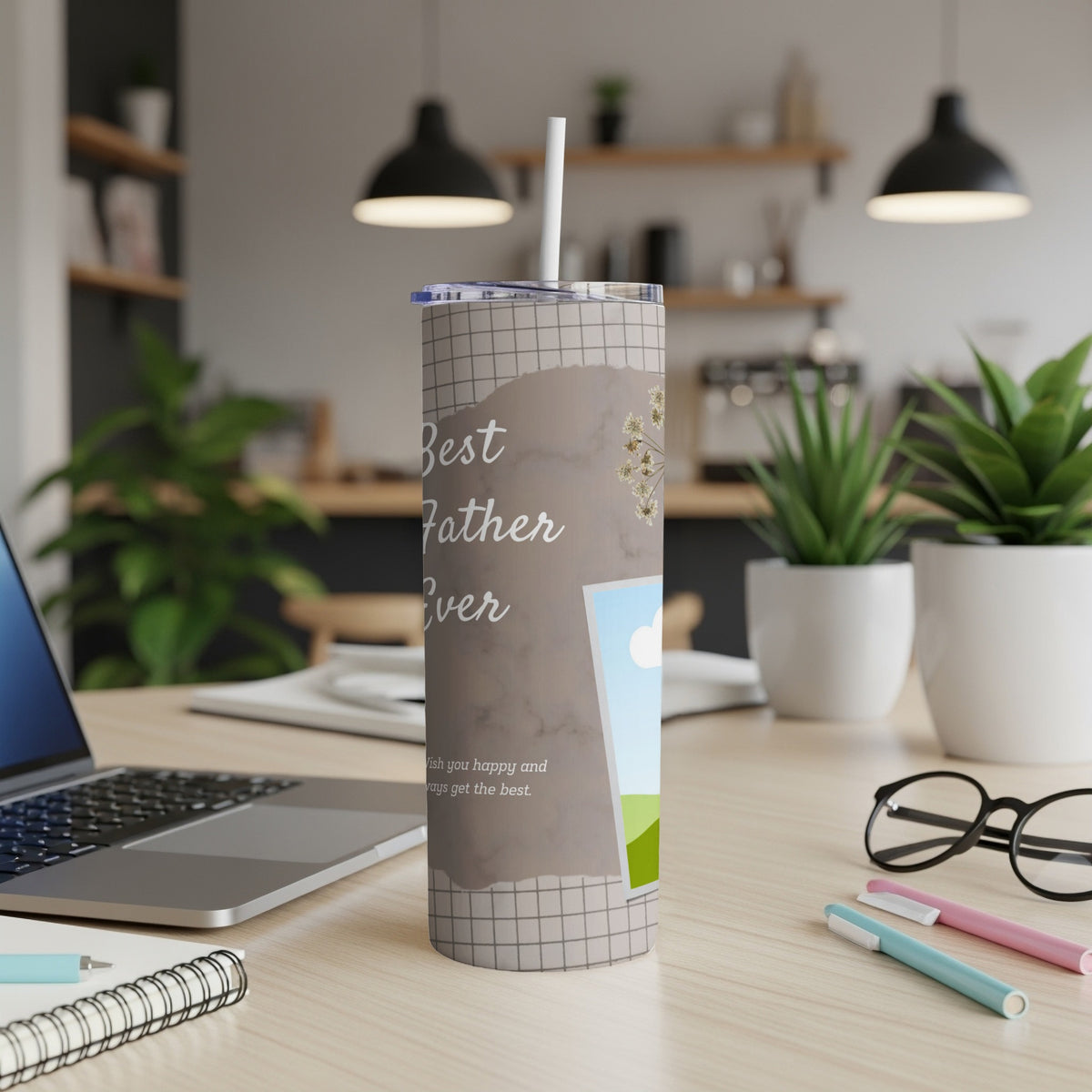 Tumbler with "Best Father Ever" text and a picture frame on a desk.